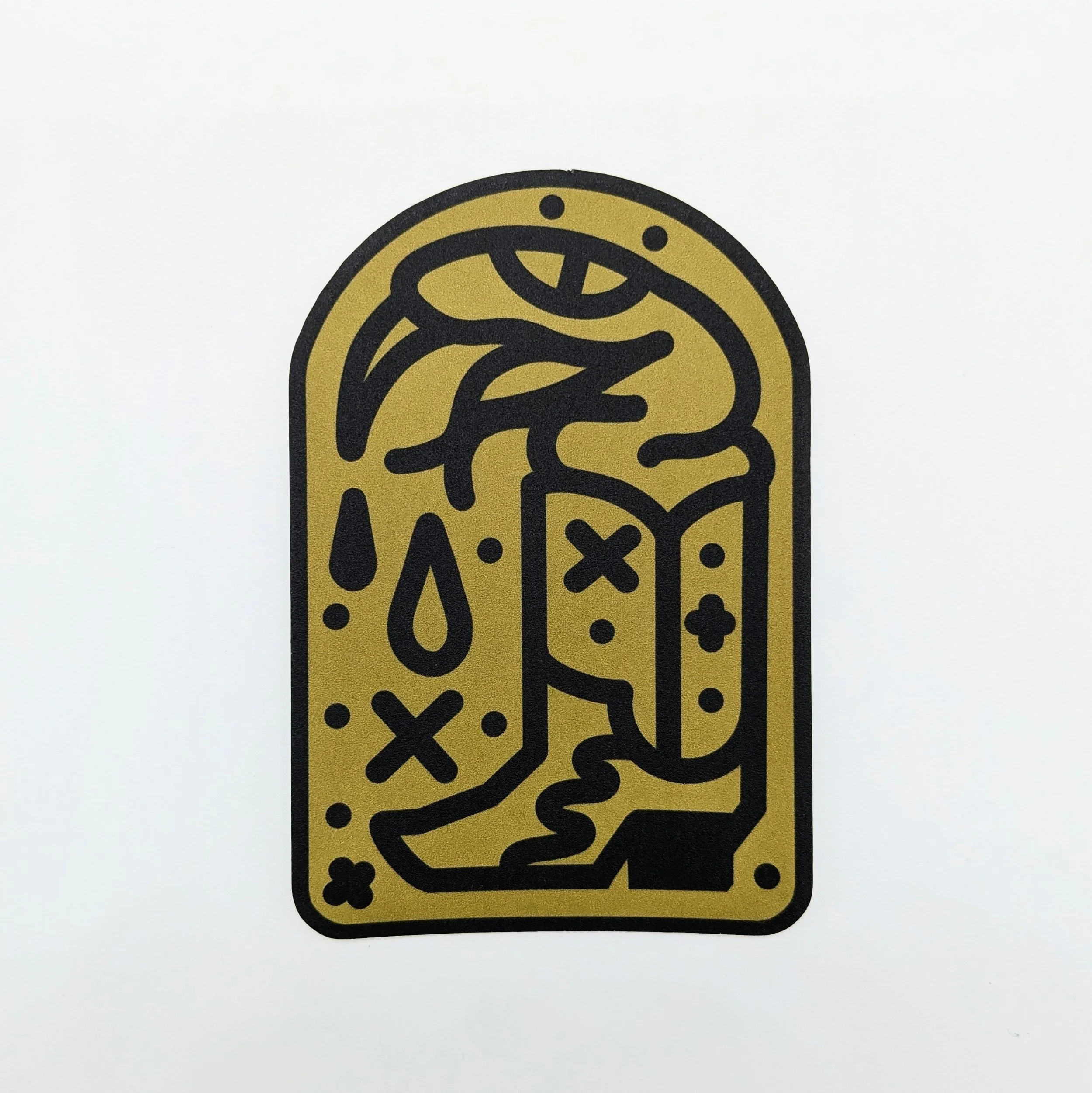 A vinyl sticker on a white backdrop, featuring an gold and black american traditional snake in a boot, with venom dripping from it's mouth. It is called the Boot Snake sticker.