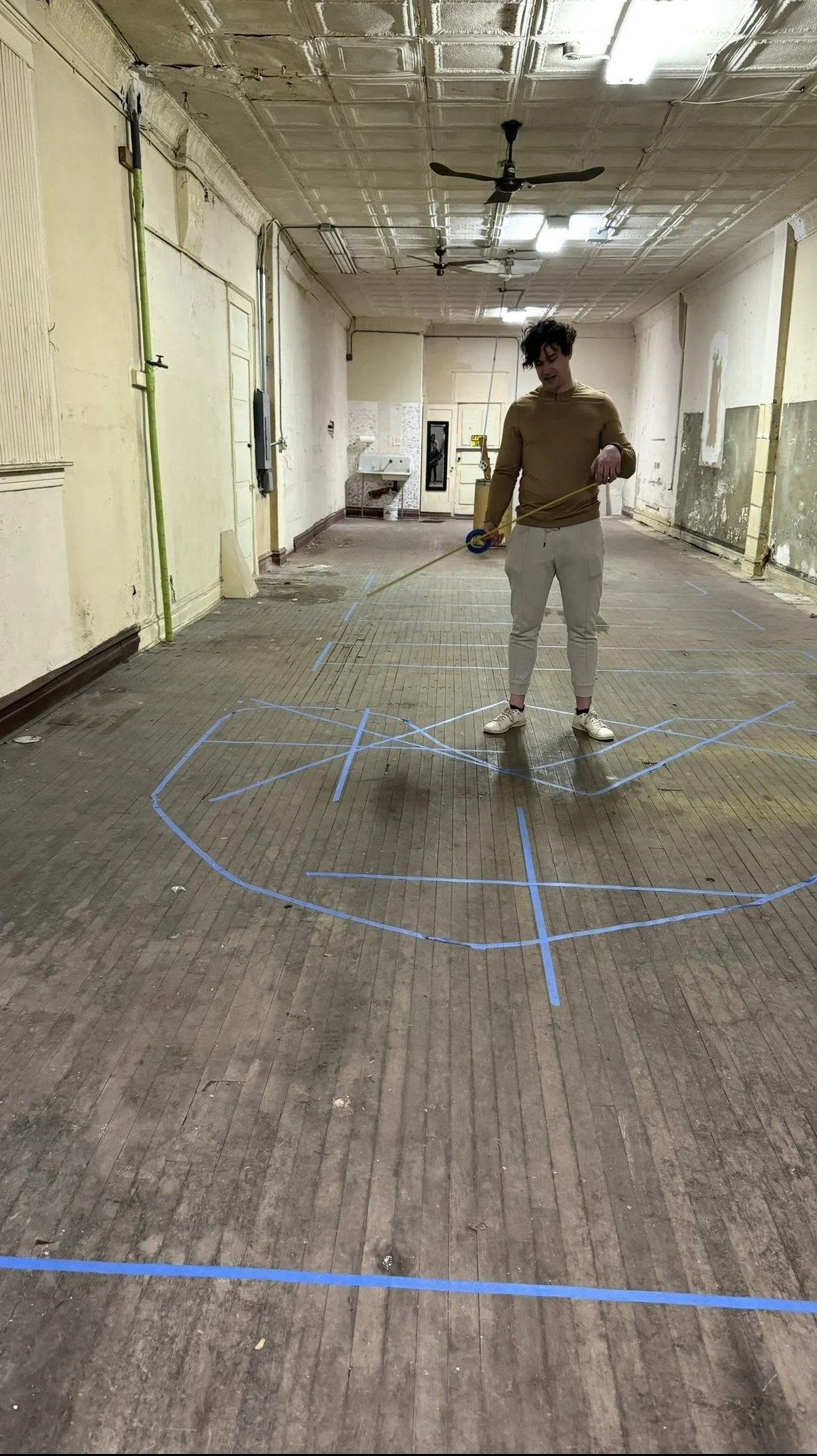 Nicolai Mlodinow drawing up floor plans on the bare floor of 1737 N Damen.