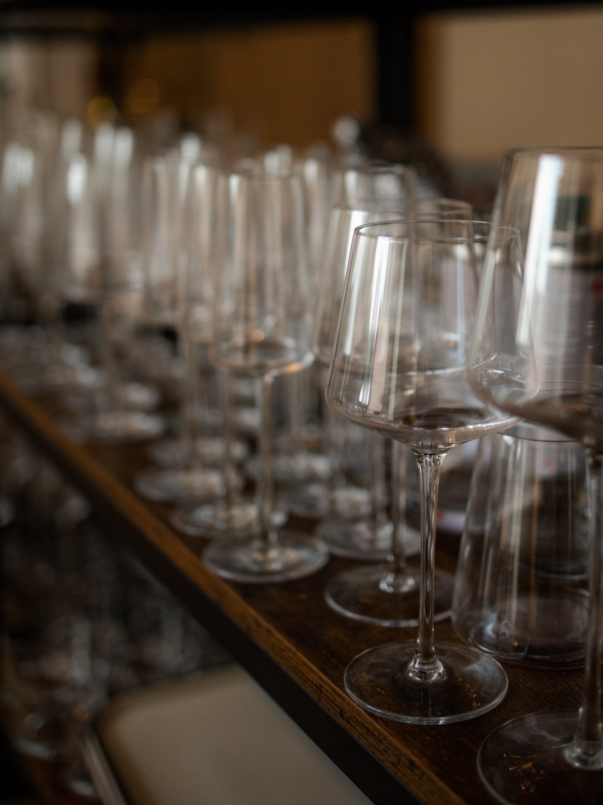 Rows of wine glasses lined up on the bar shelf at Class Act Chicago, for the Sommelier Cellar Pick add-on.