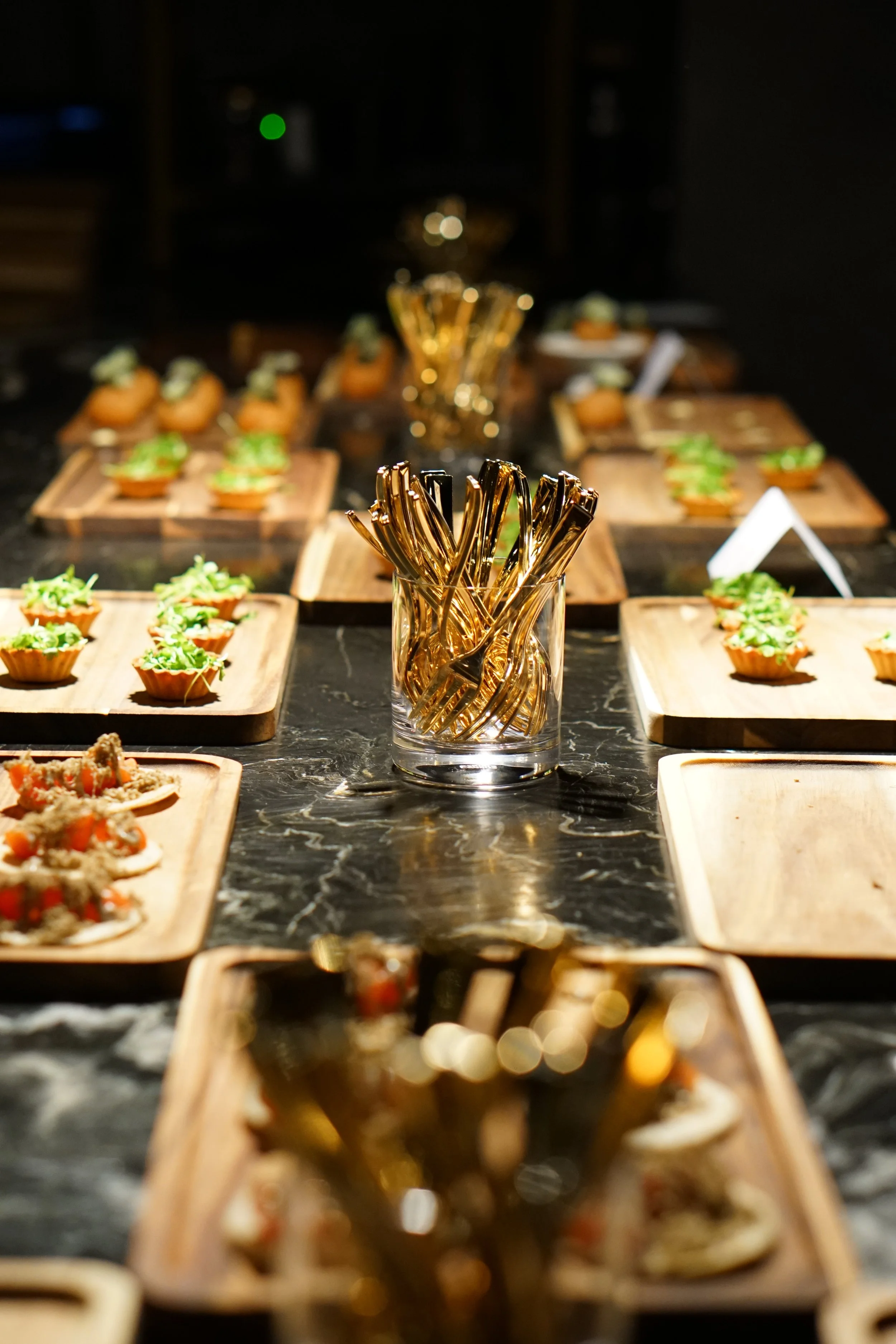 Rows of passed bites laid along the marble table for a private event at Class Act.