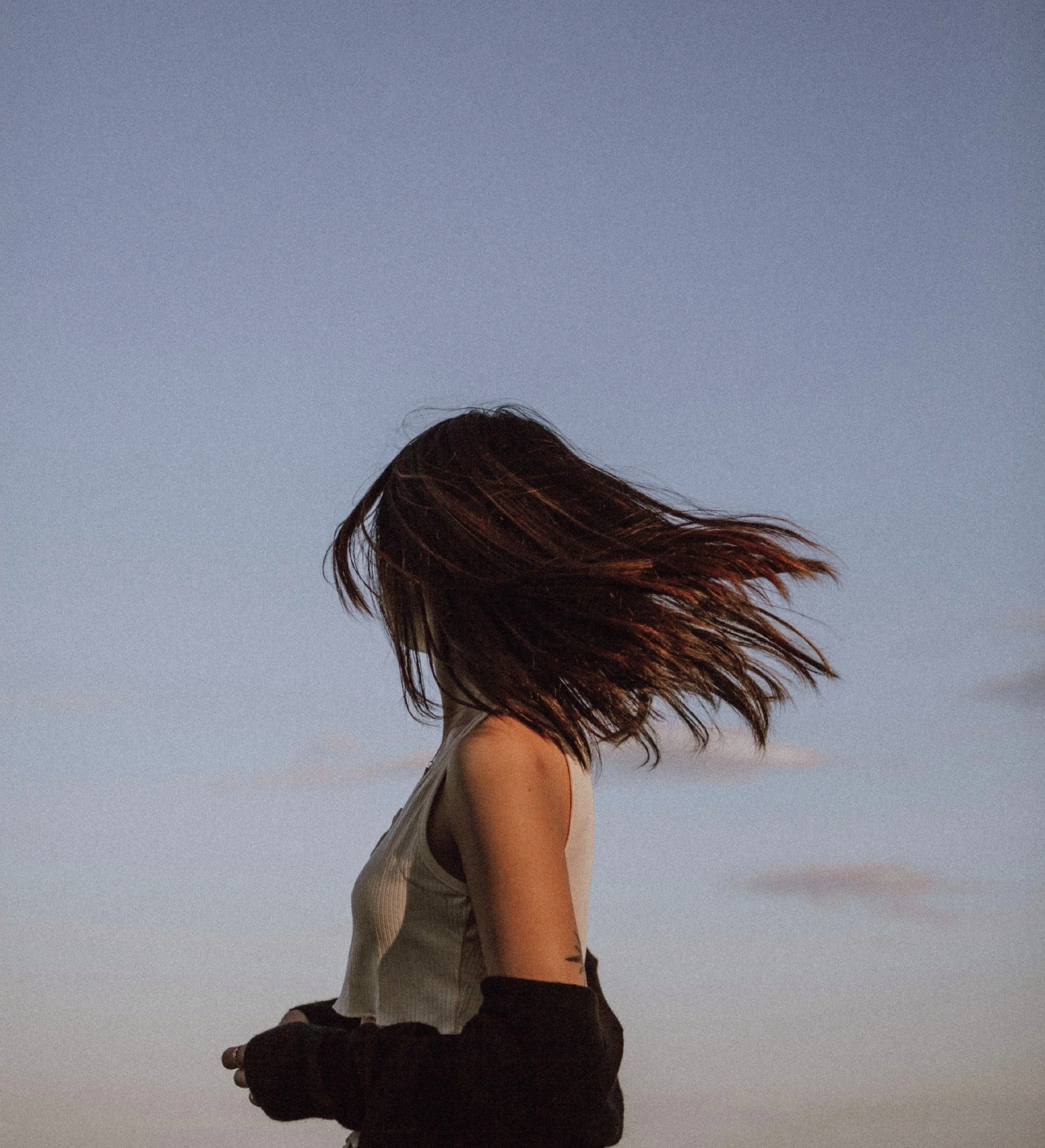Woman facing away from the camera in the wind. White Rock Therapy in Dallas, TX has expert trauma therapists in Texas here.