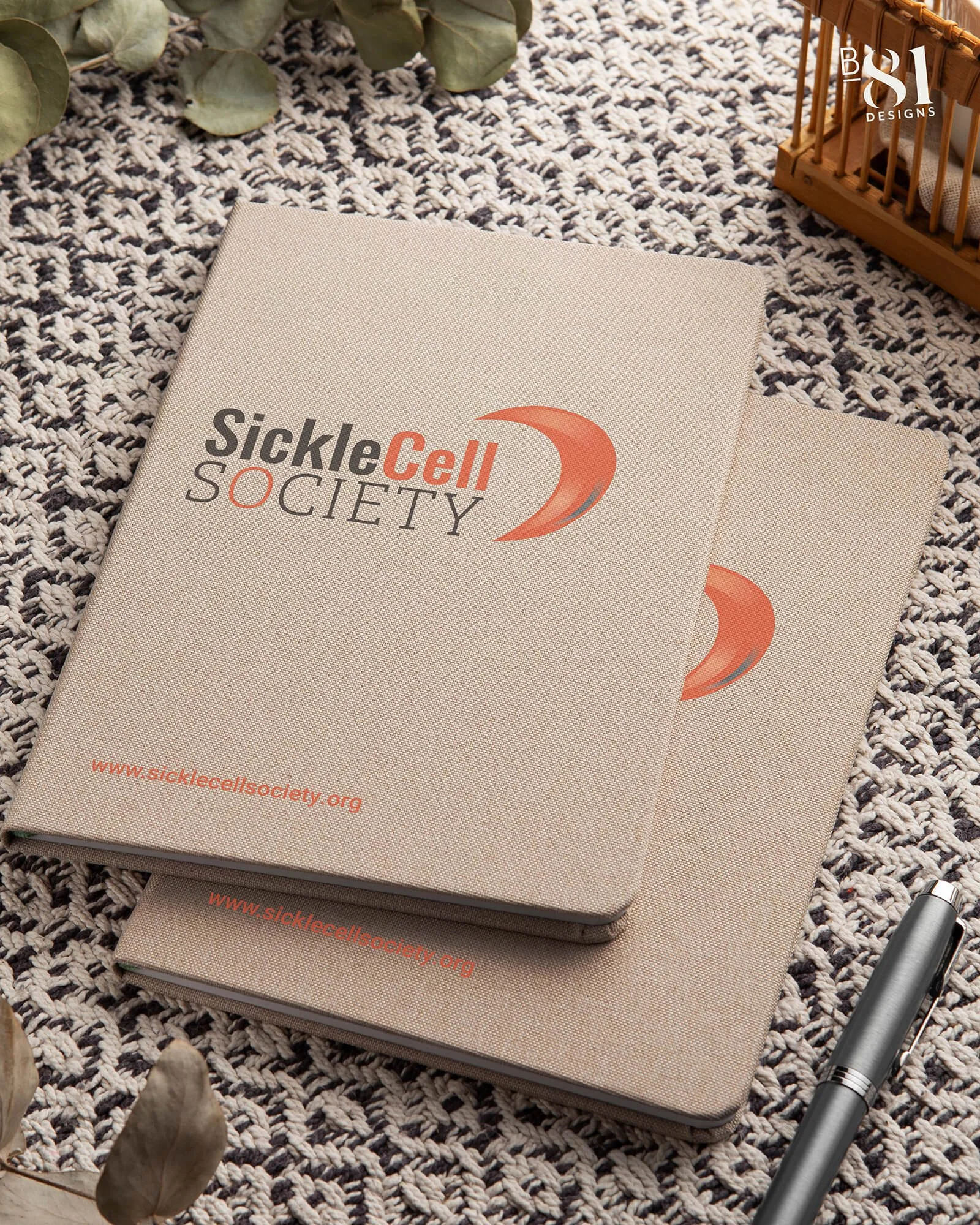 Brown notebooks with a new Sickle Cell Society logo
