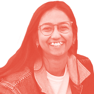 Grainy red monochrome photo of Tina Ram. She has long dark hair, is wearing round glasses, and is smiling.