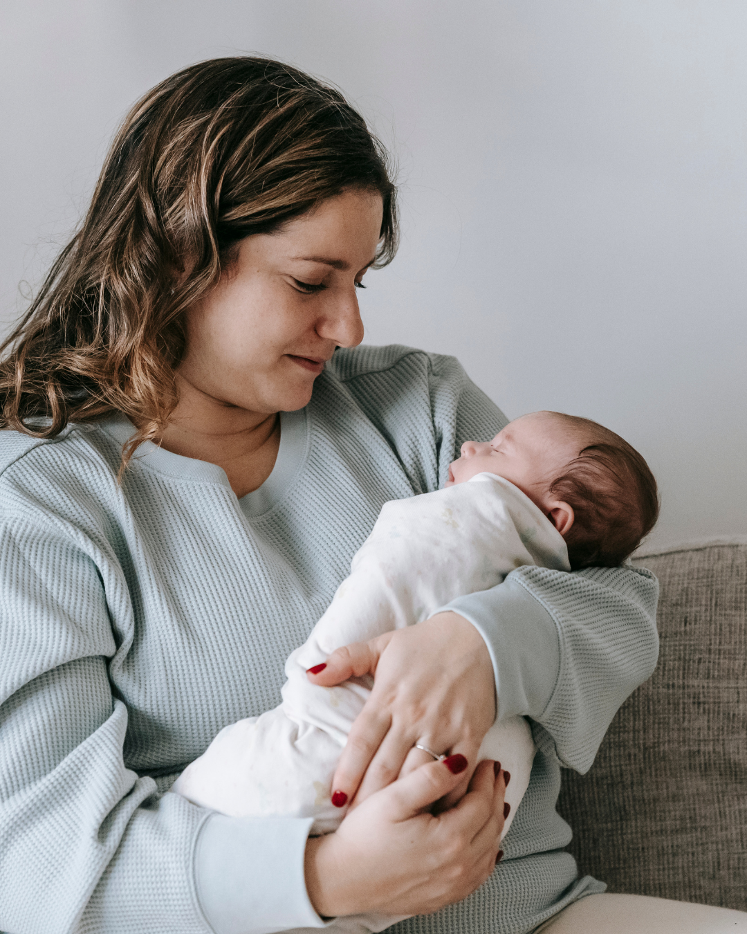 image of brown haired woman holding a sleeping infant at babyspace coachella valley palm desert ca