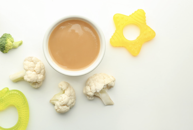 image of pureed baby food, lightly steamed broccoli and caulifower and frozen teethers
