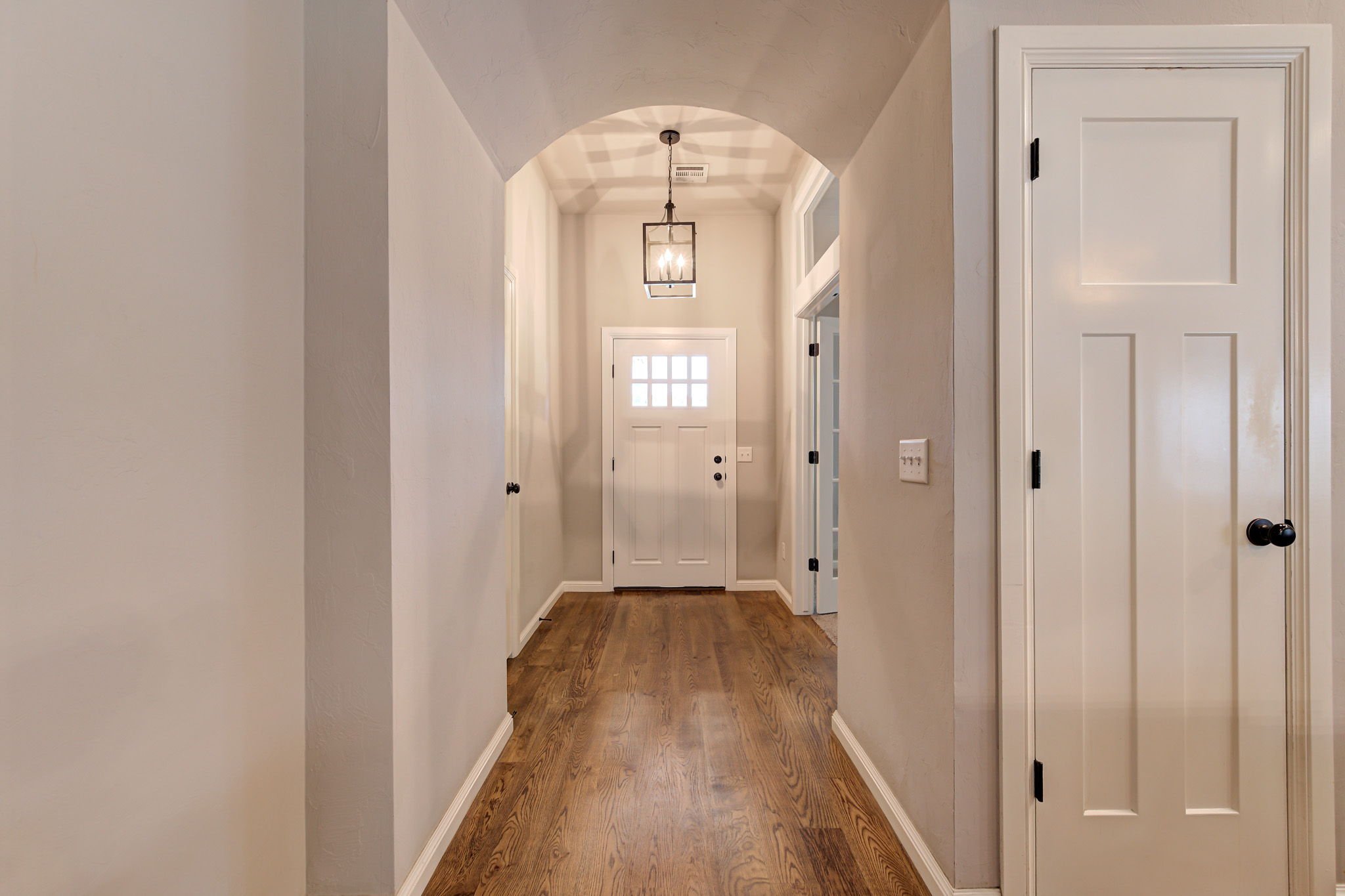 26-hallway-arched-ceiling-front-door-hardwood.jpg