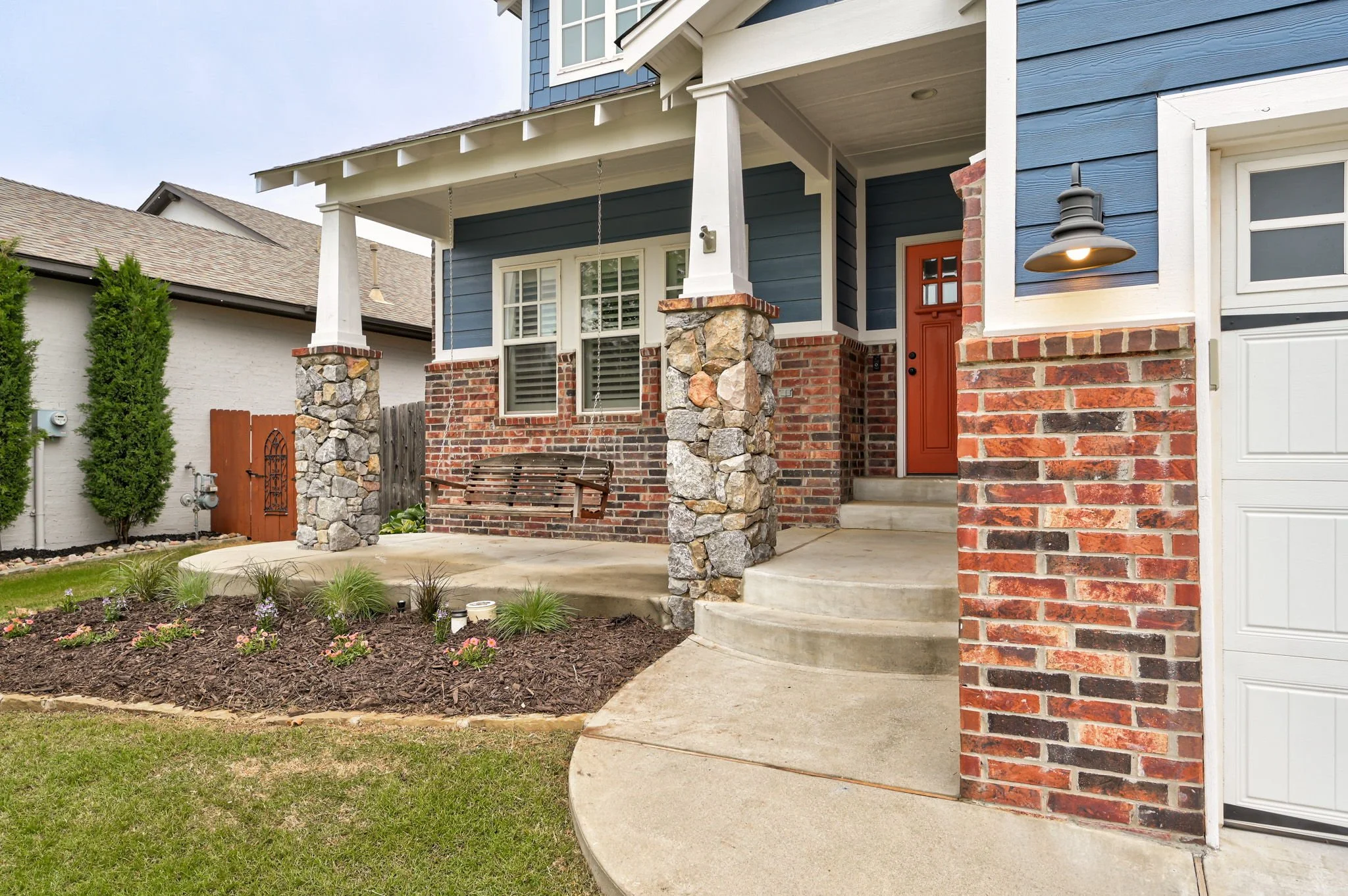 03-covered-front-porch-stone-pillars-craftsman-door.jpg