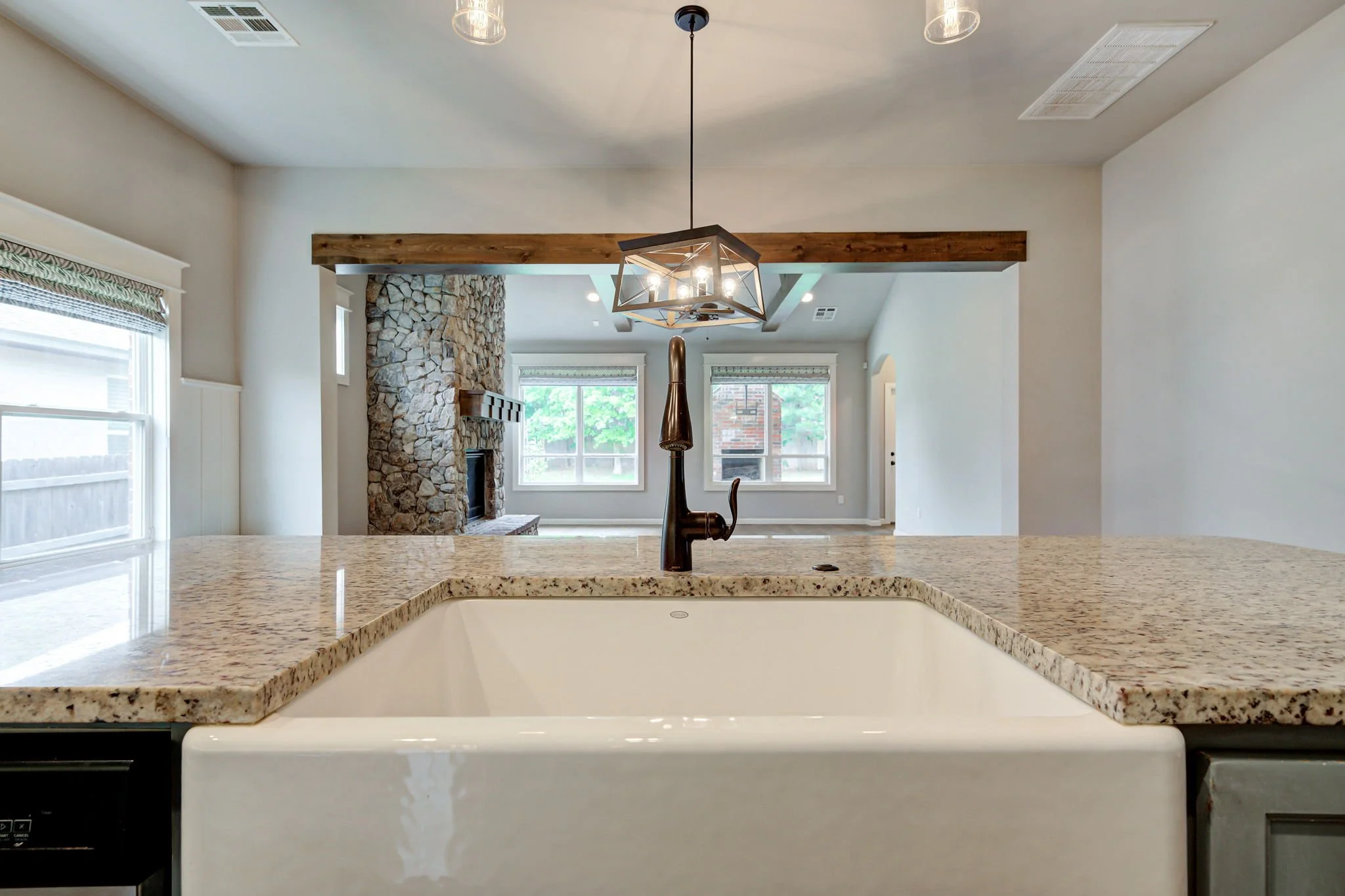 16-farmhouse-sink-granite-counters-open-living-view.jpg