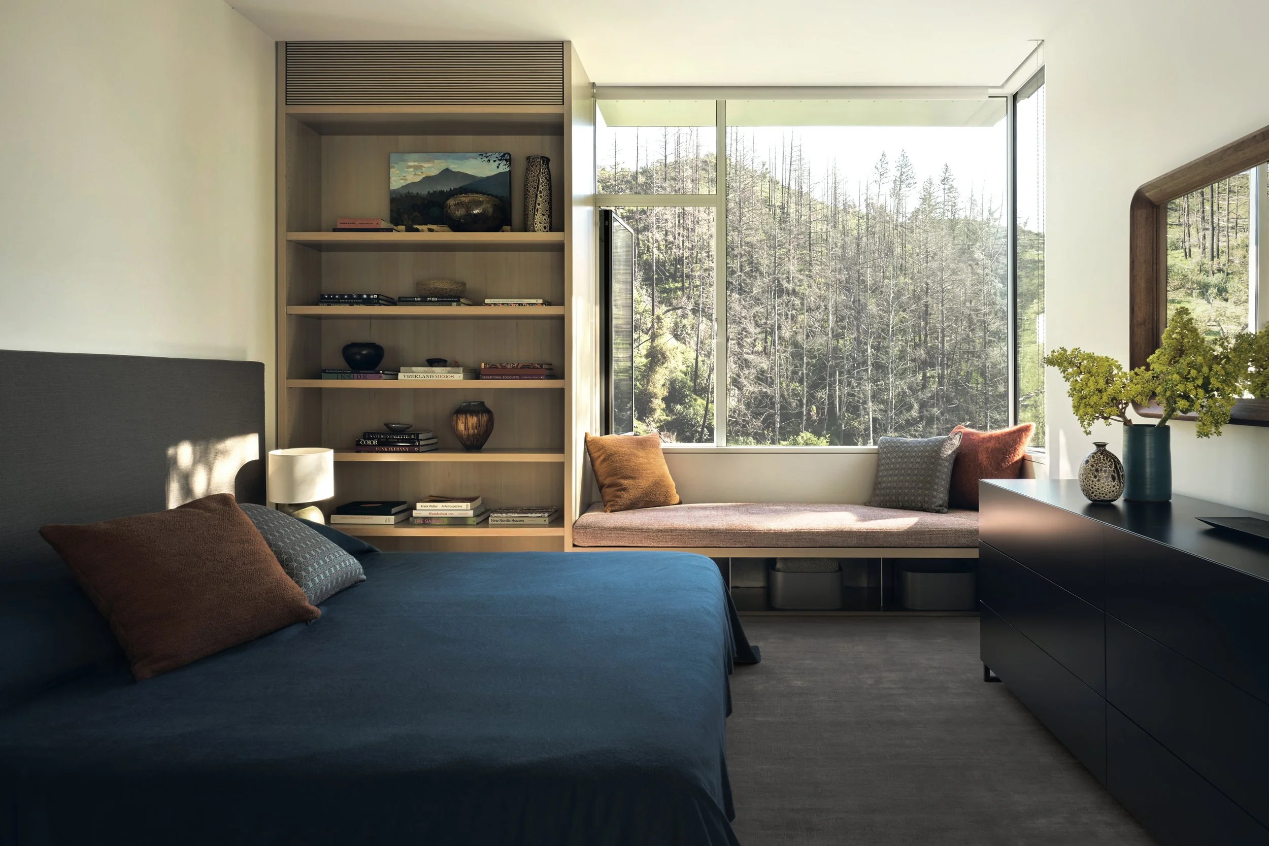 Modern living room with oversized windows, landscape views, and custom upholstered lounge chairs