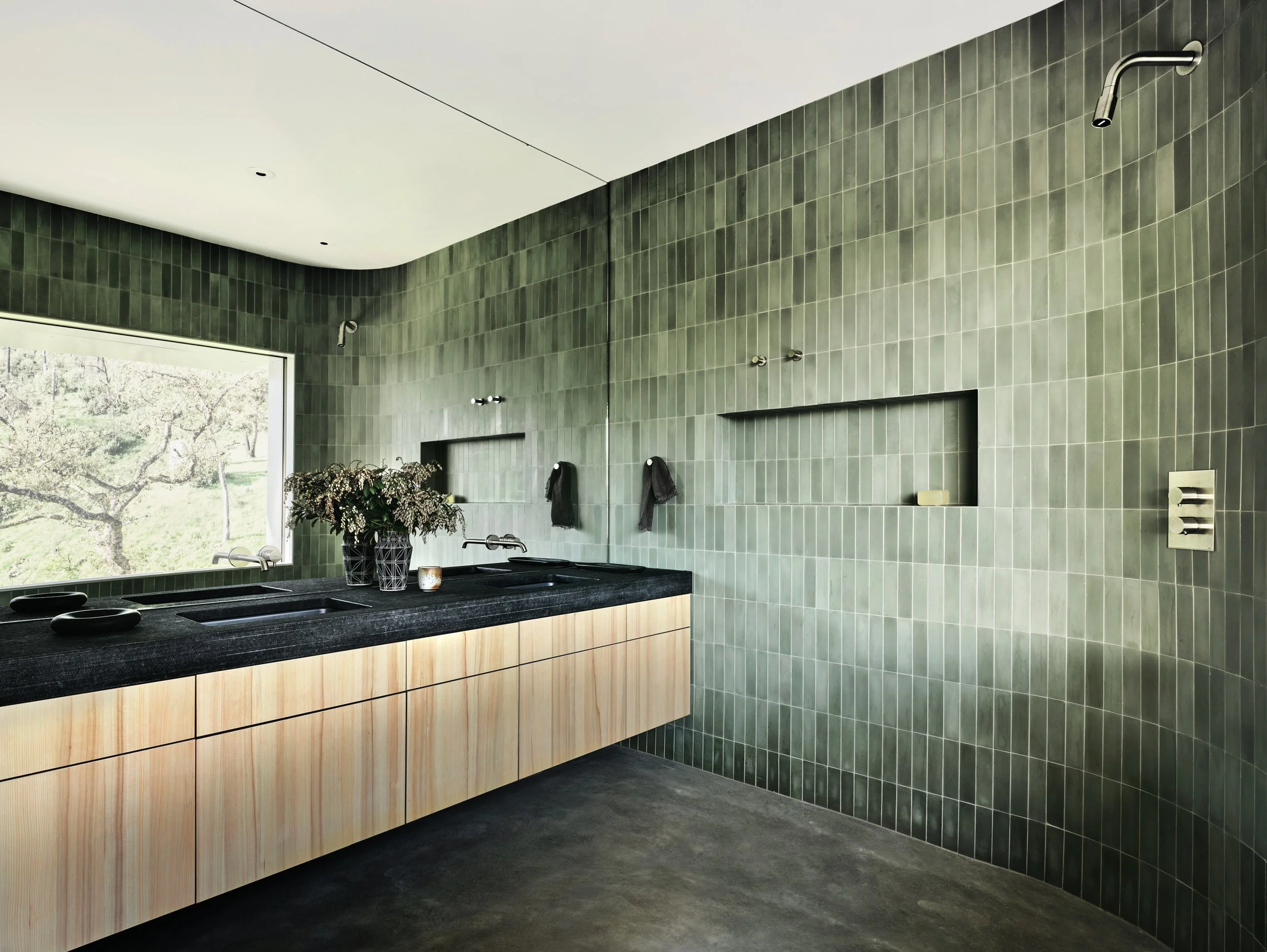 Luxury modern bathroom with green tile walls, wet room shower, and floating double vanity