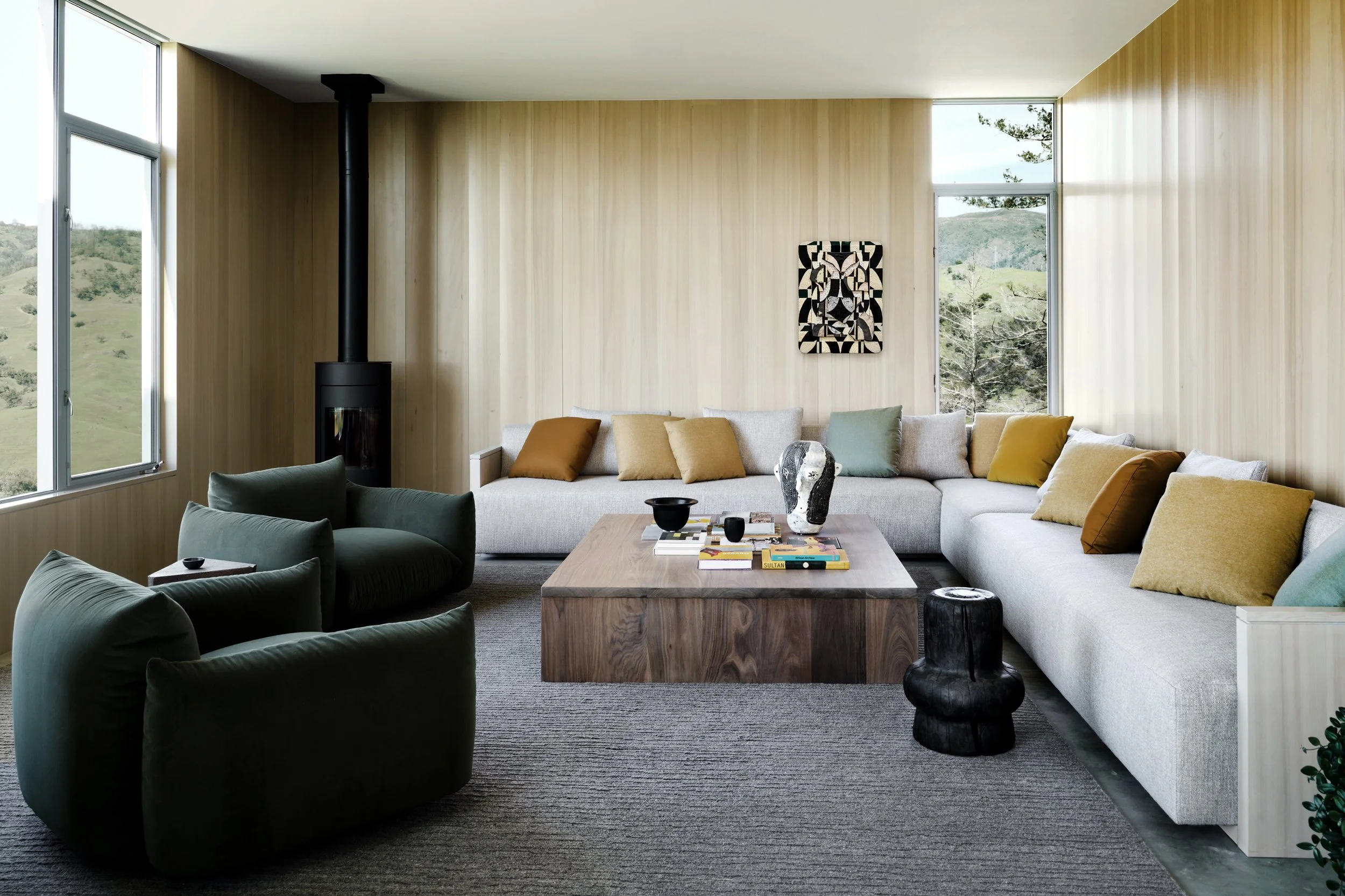 Luxury modern living room with custom sectional sofa, wood paneled walls, and minimalist designer furnishings