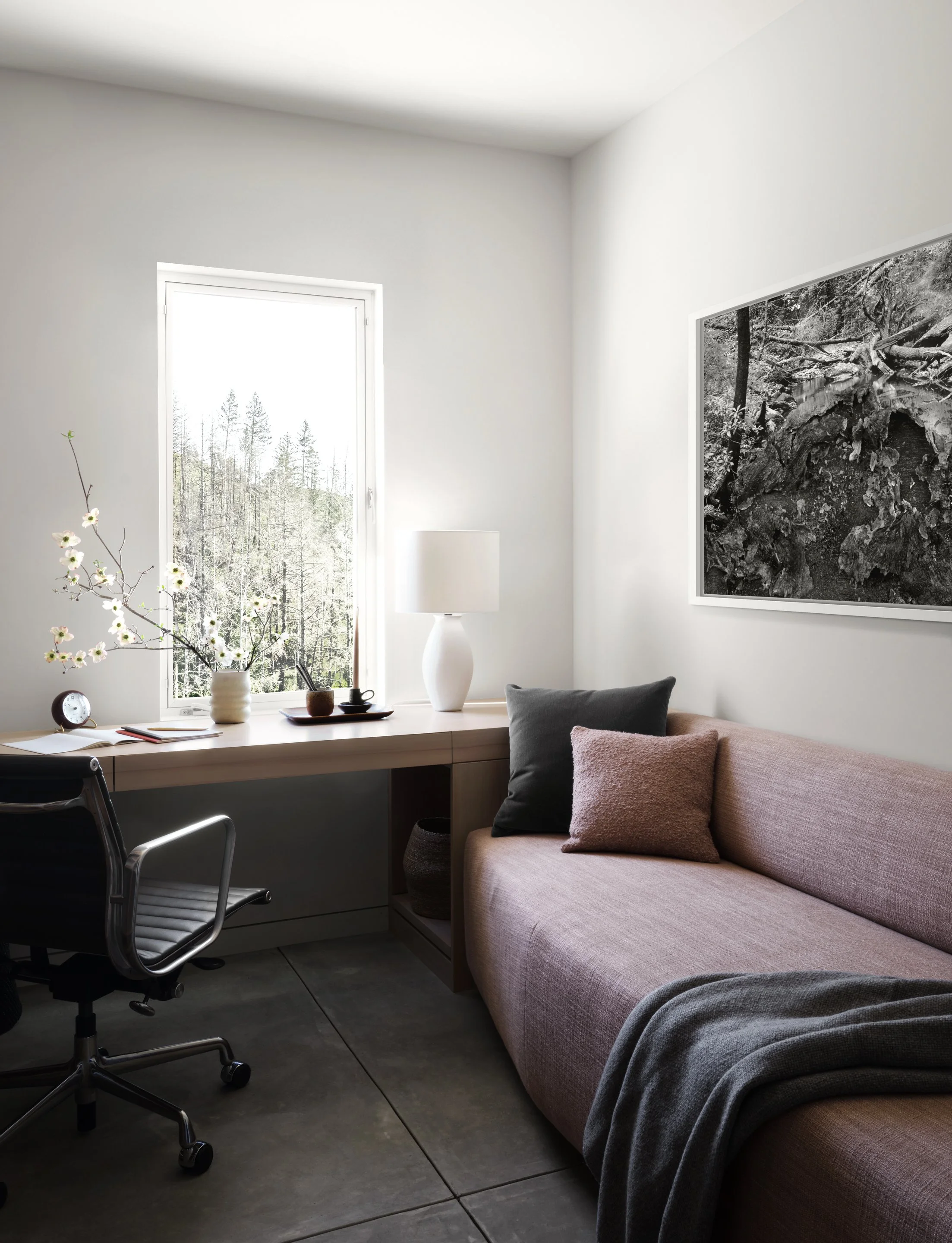 Modern home office and guest room with built in desk, custom sofa, and minimalist decor