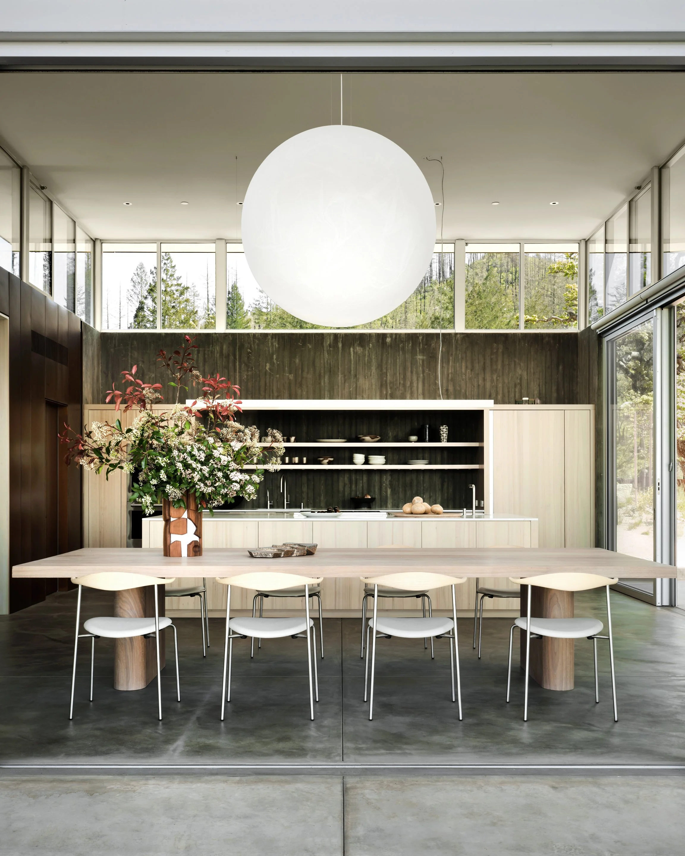 Luxury modern kitchen and dining space with custom wood cabinetry, open plan layout, and architectural interiors