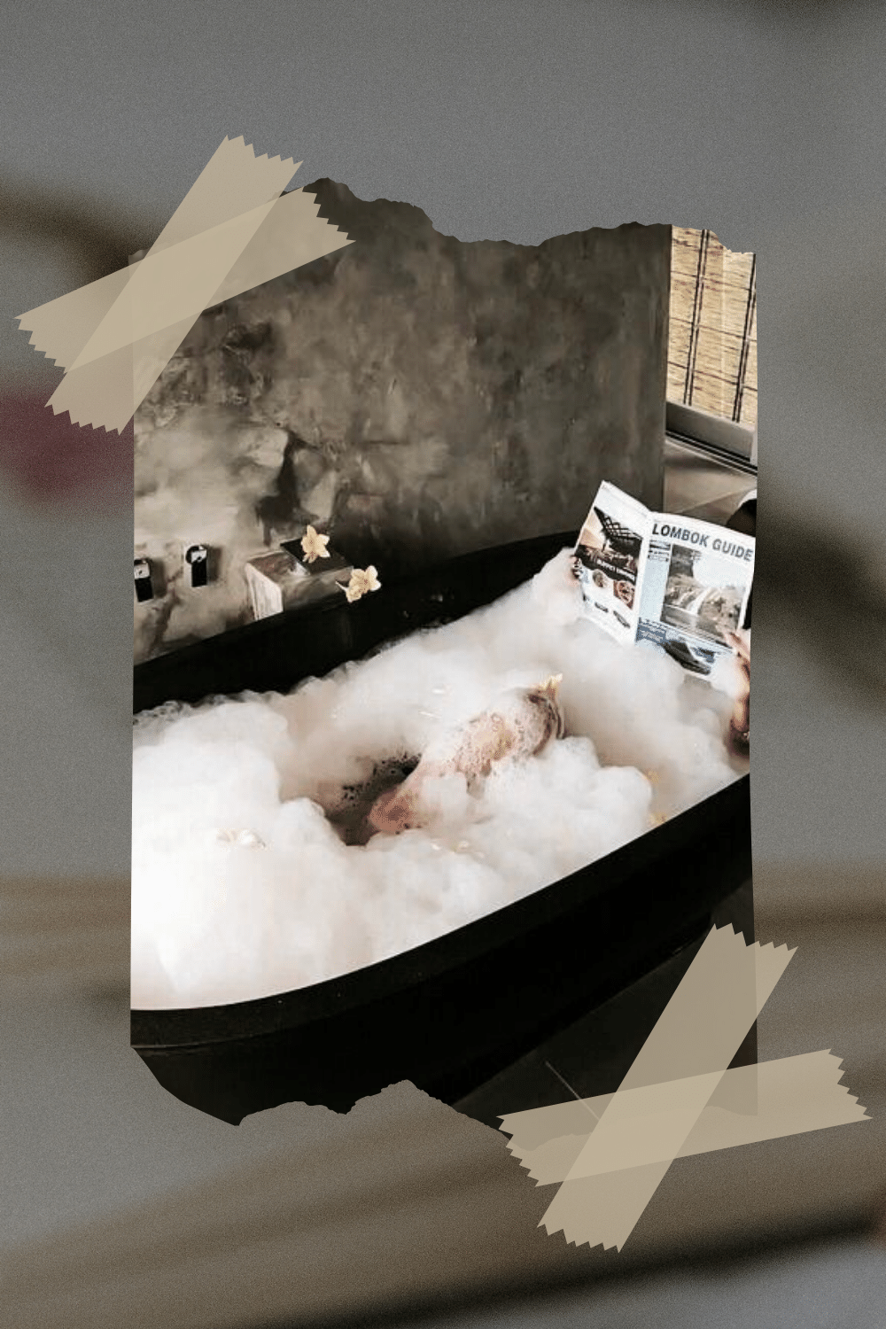 Person relaxing in a bubble bath with a tropical drink and a 'Lombok Guide' pamphlet, surrounded by tropical decor.