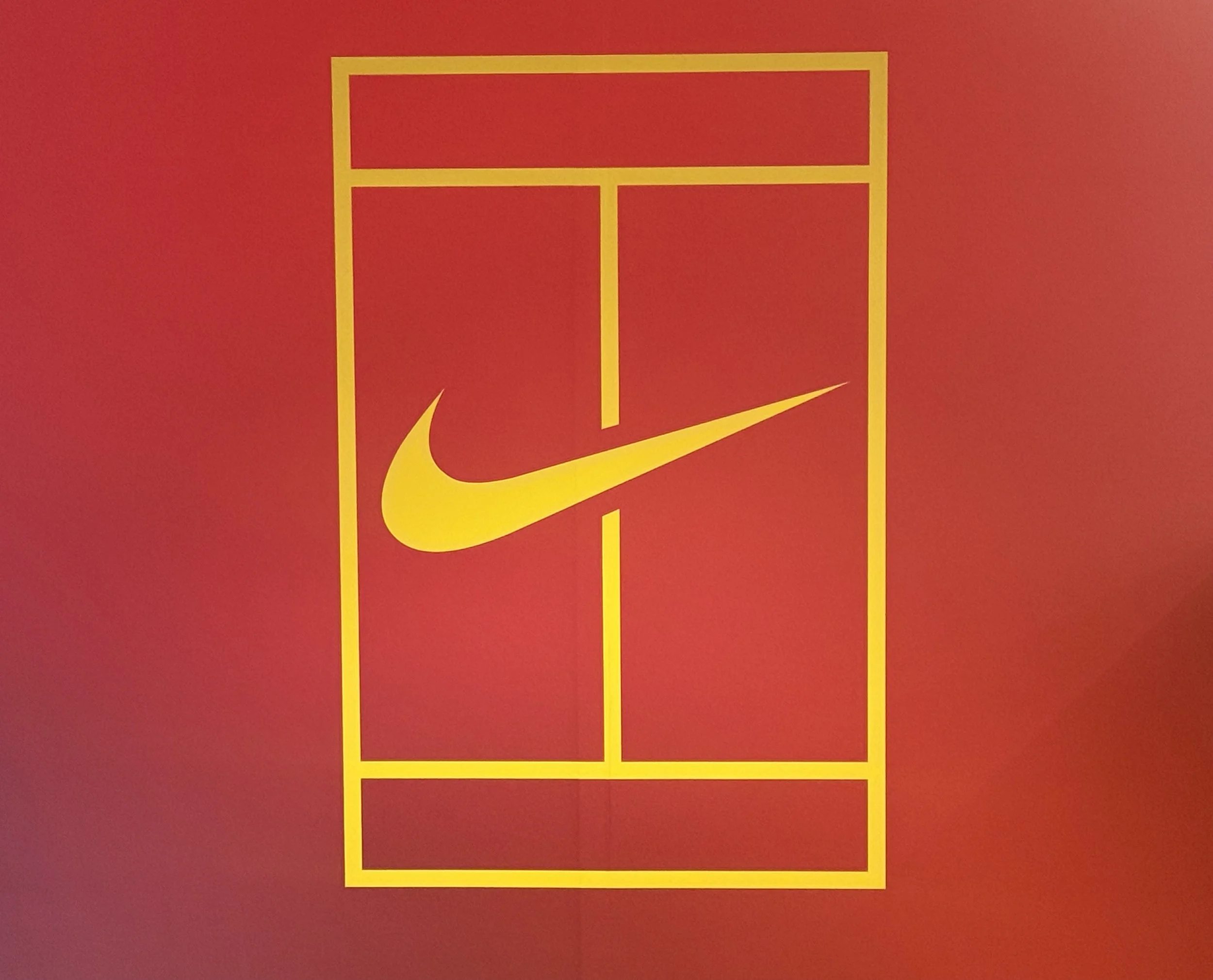 Red poster with yellow outline of a tennis court and a yellow Nike swoosh logo in the center.