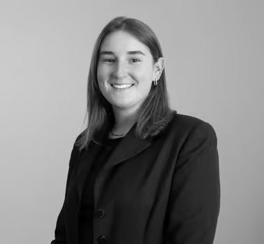 Black and white photo of a smiling woman with shoulder-length hair, wearing a blazer.