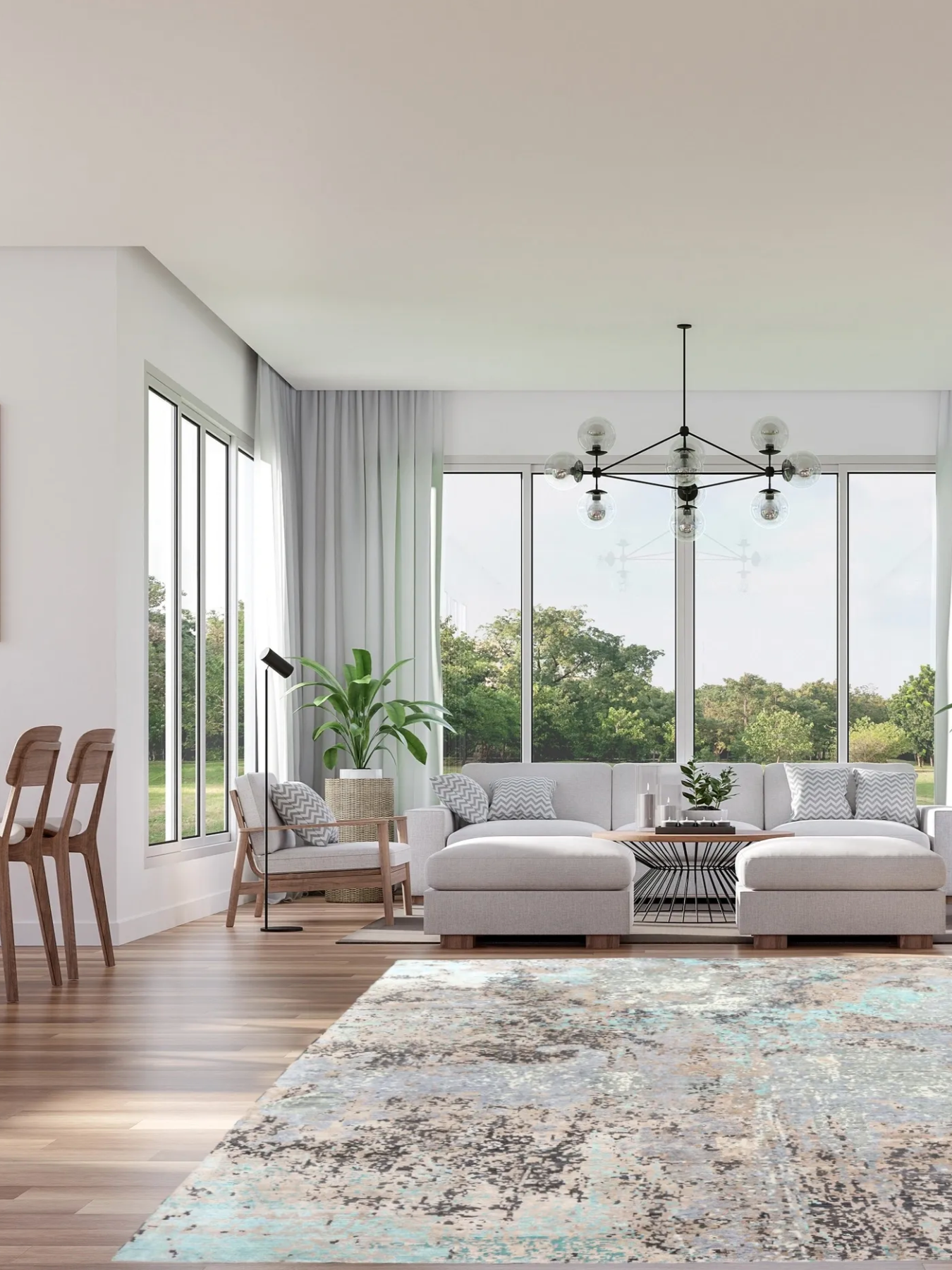 Living room with white sofa, patterned pillows, glass coffee table, potted plant, large windows with white curtains, wooden chairs, modern chandelier, and an area rug with blue, beige, and black abstract design.