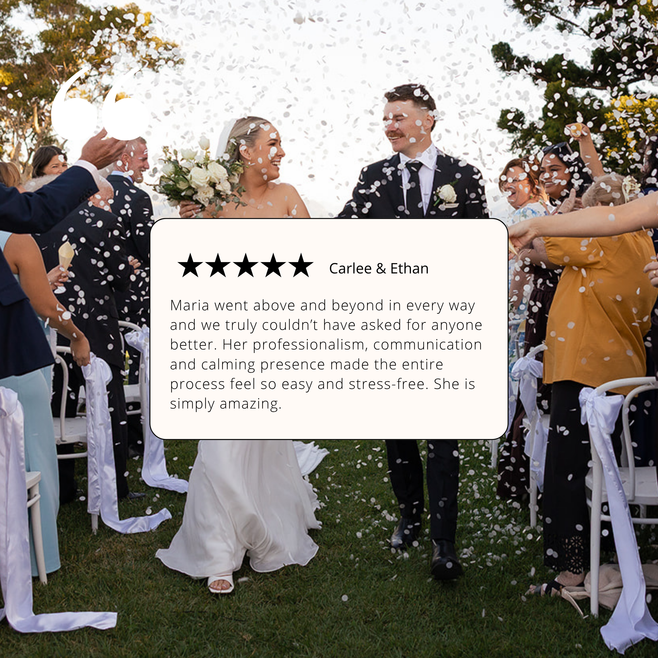 Bride and groom walking through confetti under a decorated white archway at an outdoor wedding reception, smiling and holding hands.