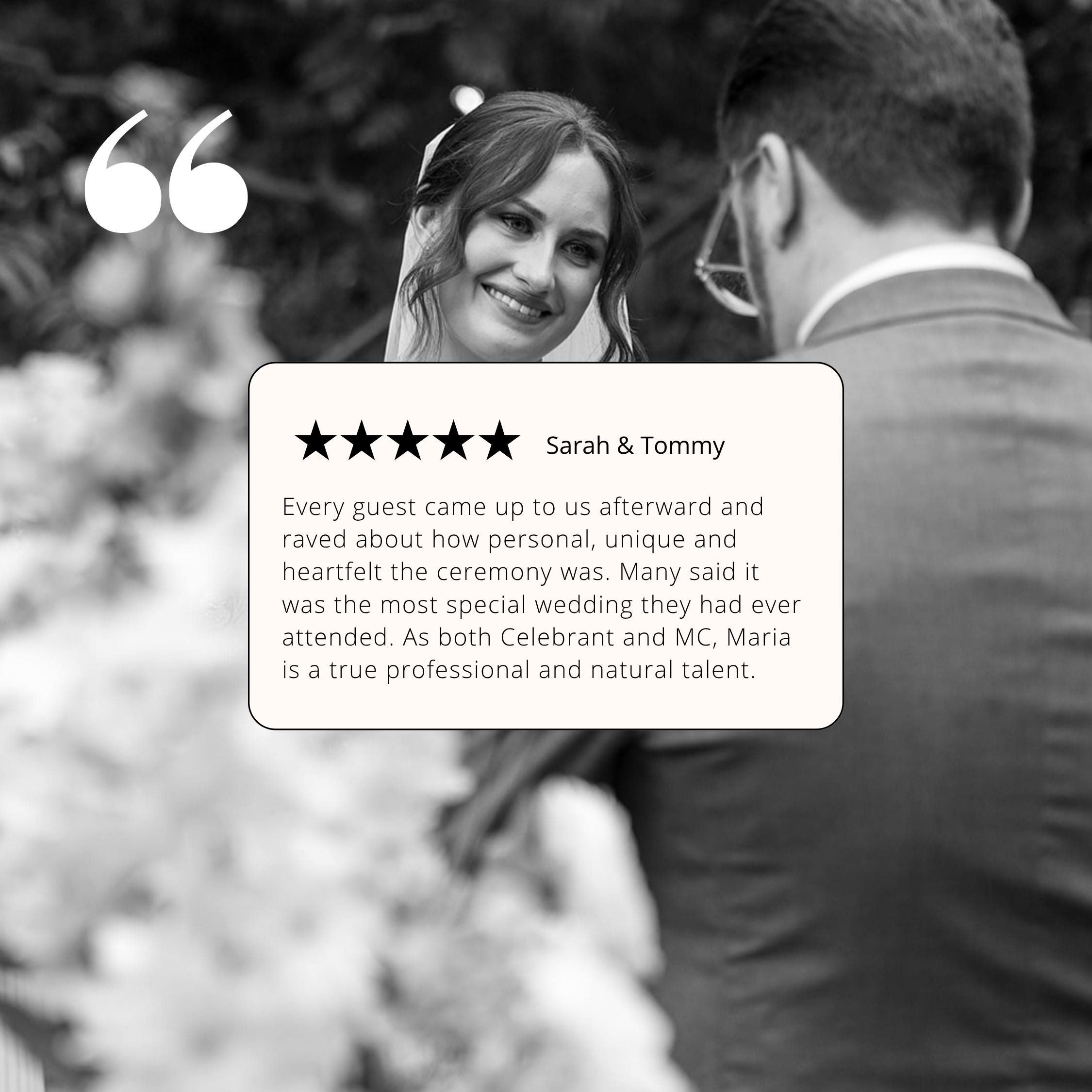 Black and white photo of a woman with wavy hair smiling and looking at a man wearing glasses in formal attire, with outdoor trees blurred in the background.