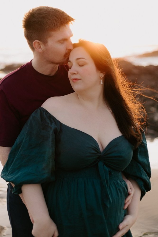 Nicole Johnson Photography ~ Maternity session on beach, couple embracing, kiss on head