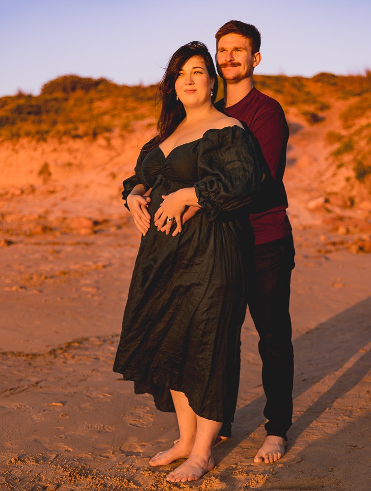 Nicole Johnson Photography ~ Maternity Session, couple embrace hands on baby bump golden hour on beach