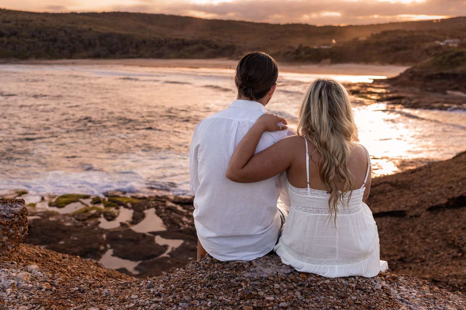 Nicole Johnson Photography ~ Couple session overlooking beach in distance, sitting on rocks