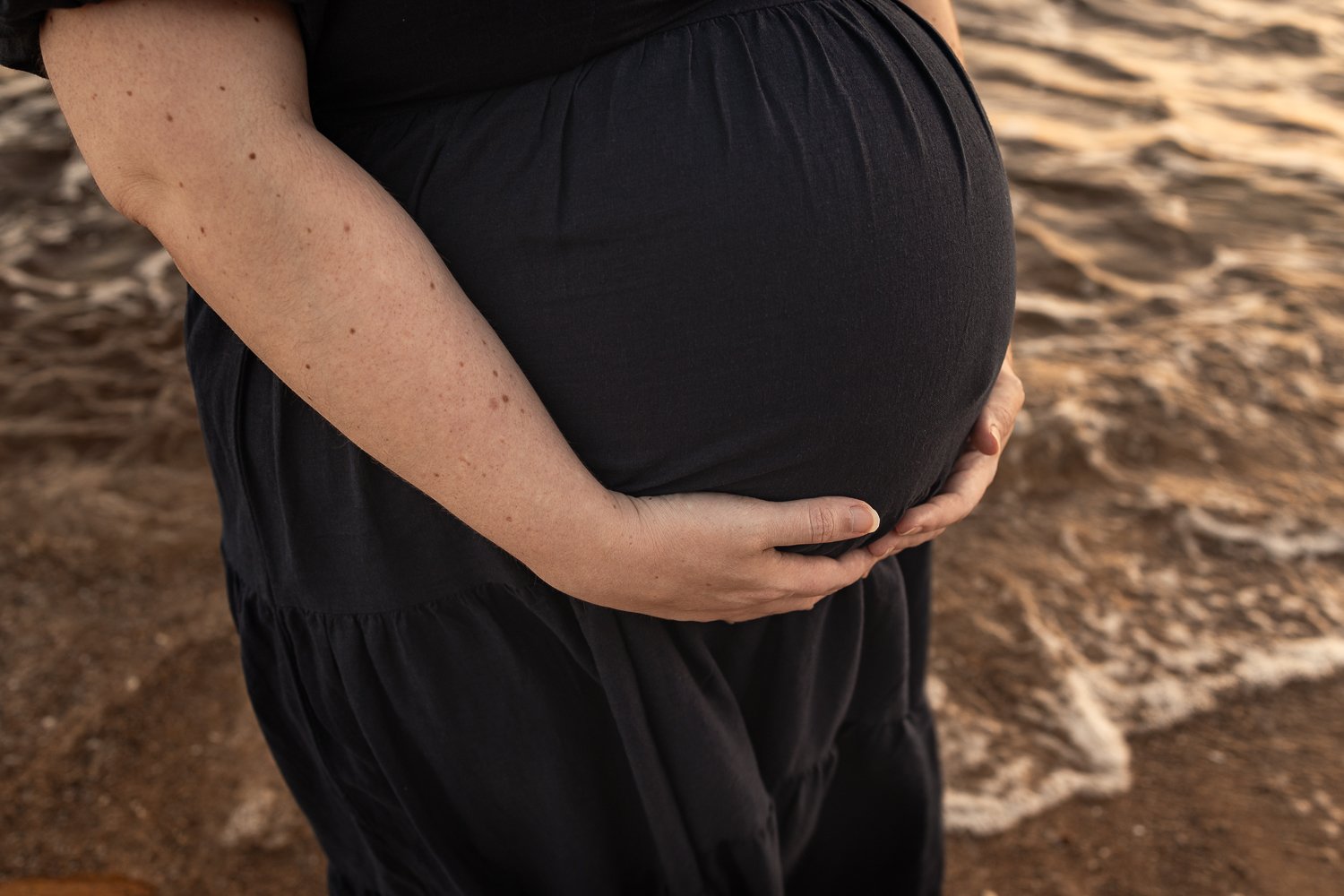 Nicole Johnson Photography ~ Maternity beach session, Mother cradling baby bump
