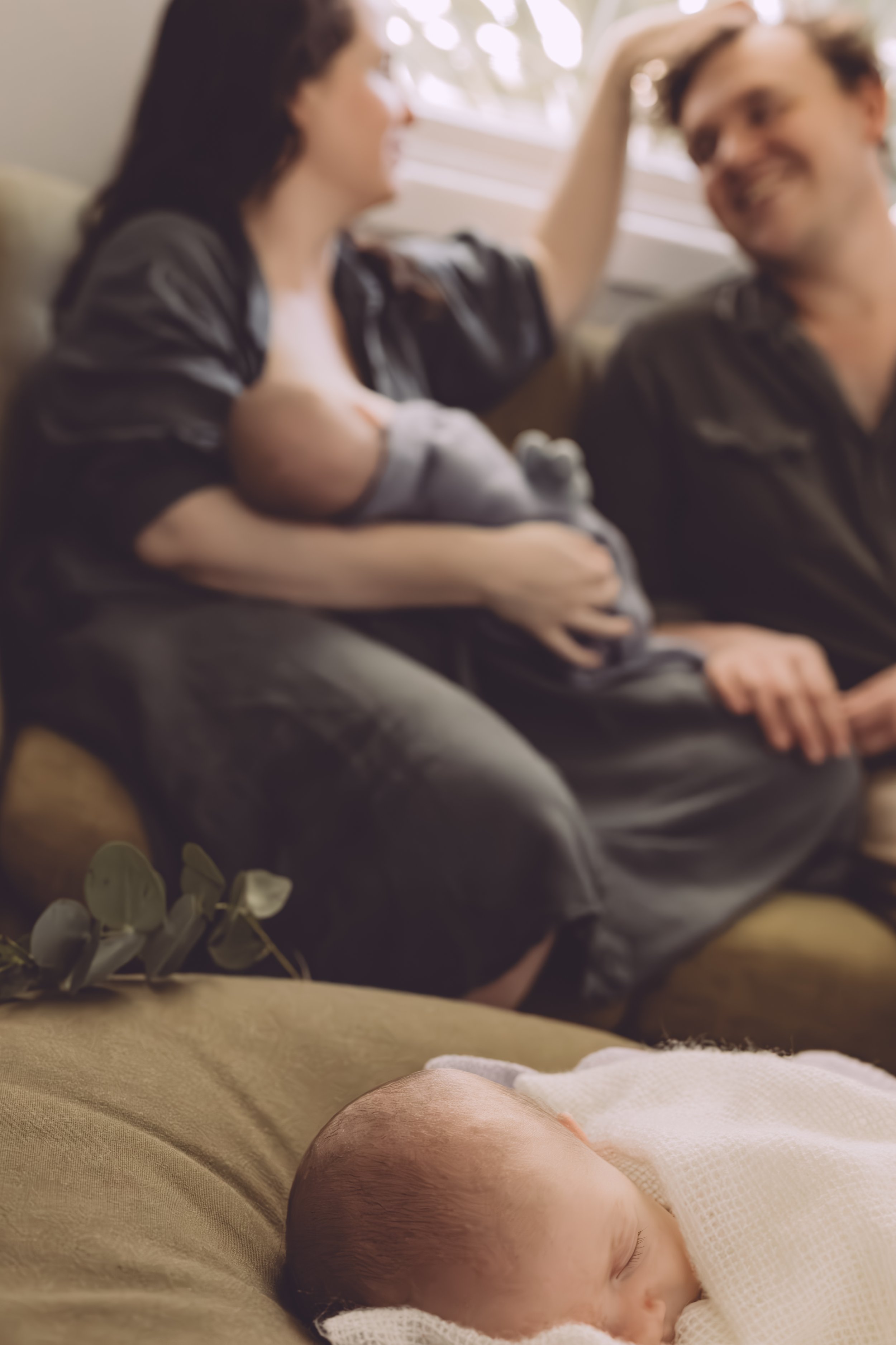 Nicole Johnson Photography ~ Newborn session, couple on lounge with one child, tender moment, next child in forefront