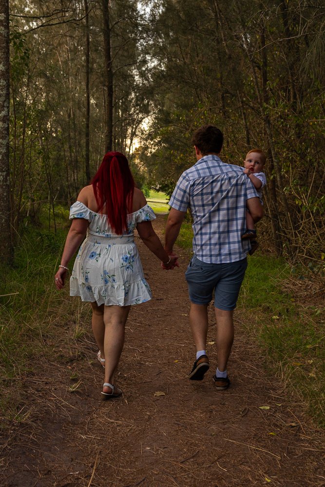 Nicole Johnson Photography ~ Family lifestyle session, Walking through forest family of three holding hands.
