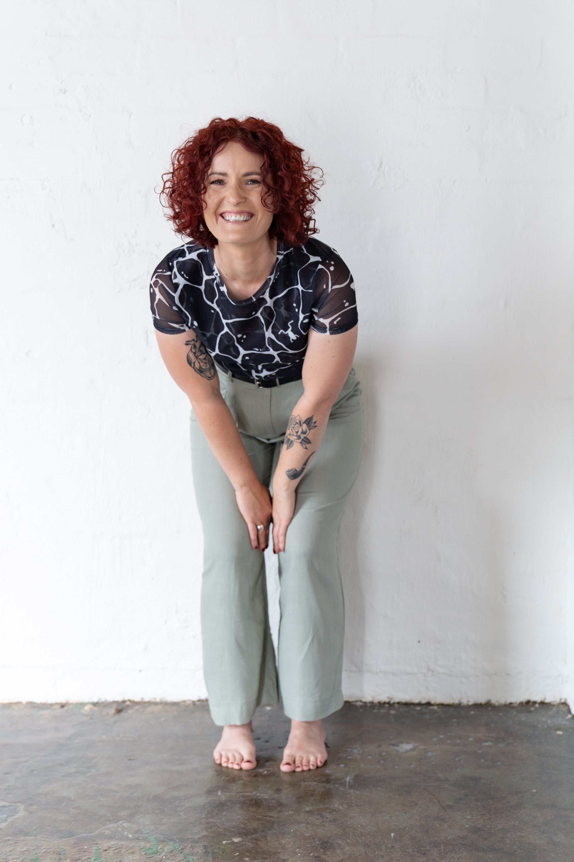 Founder and Facilitator, Kylie, slightly bending over and laughing.