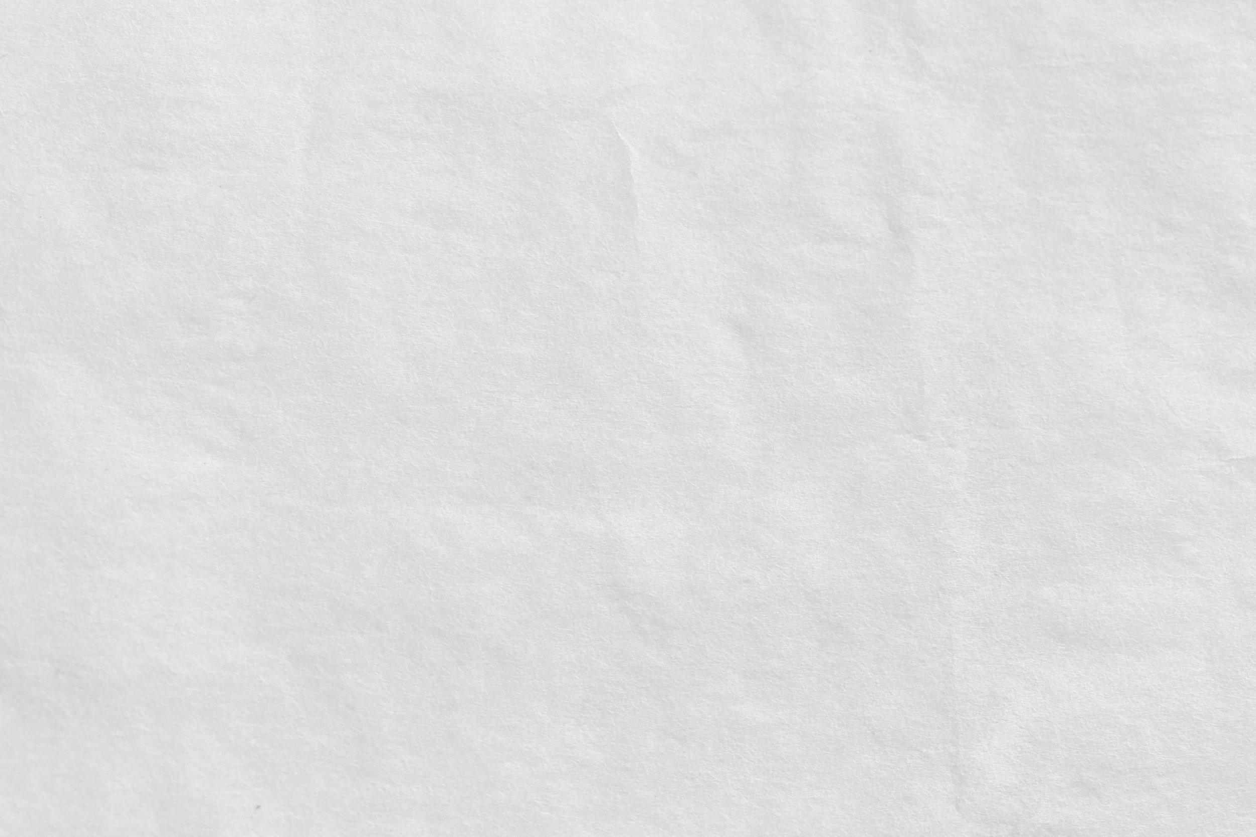 Blank white paper background with subtle texture and faint creases.