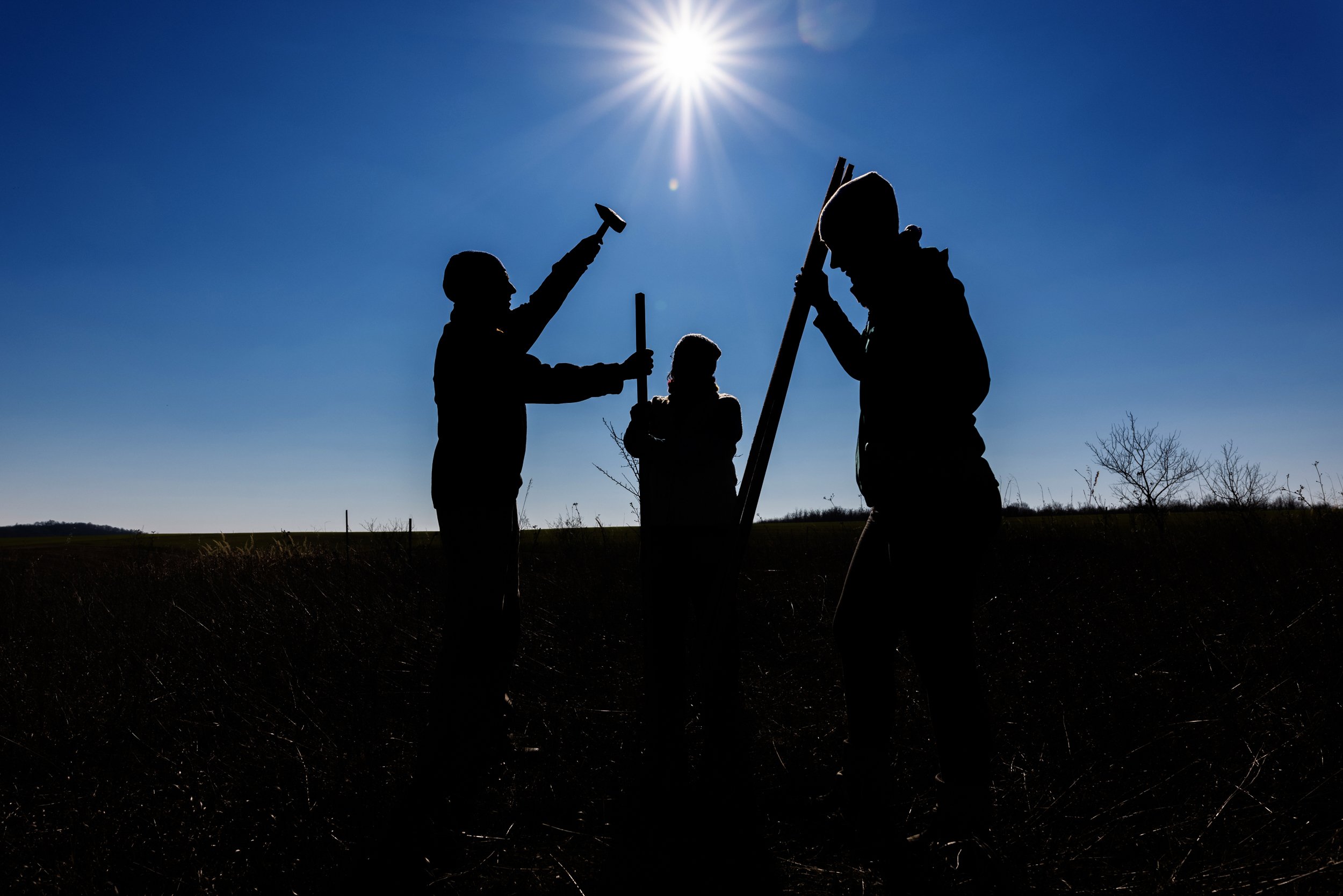  Three members of the Nyim Eco Community marking the locations of the future trees on the Eco-meadow on the outskirts of Nyim on March 13, 2022. The group planted 1,200 trees – forest saplings and landrace fruit trees – during the last season, from a