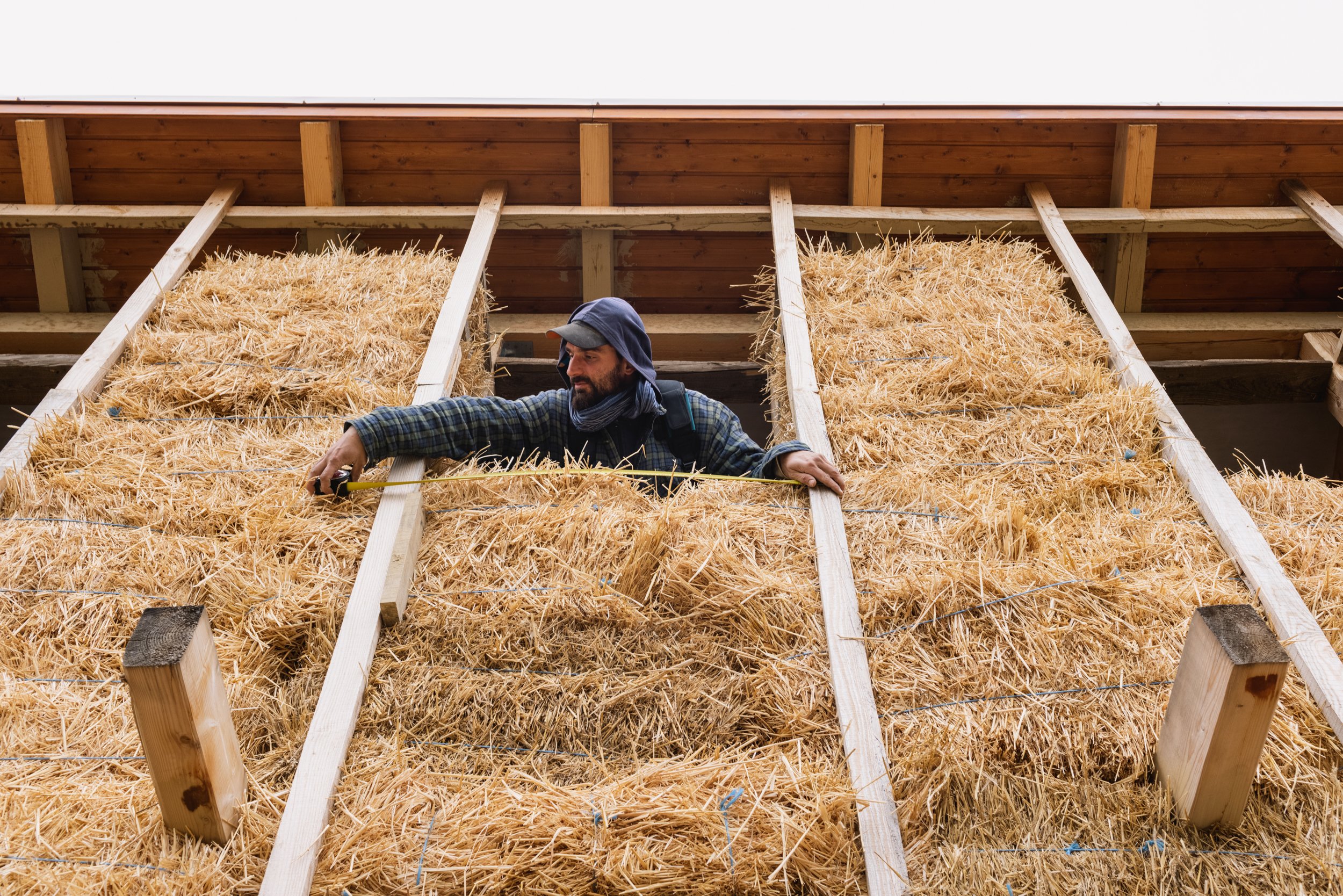  György Guti voluteer measuring the distance of straw-bales of the straw and mud house under construction in the outskirts of Nyim on September 25, 2022. 