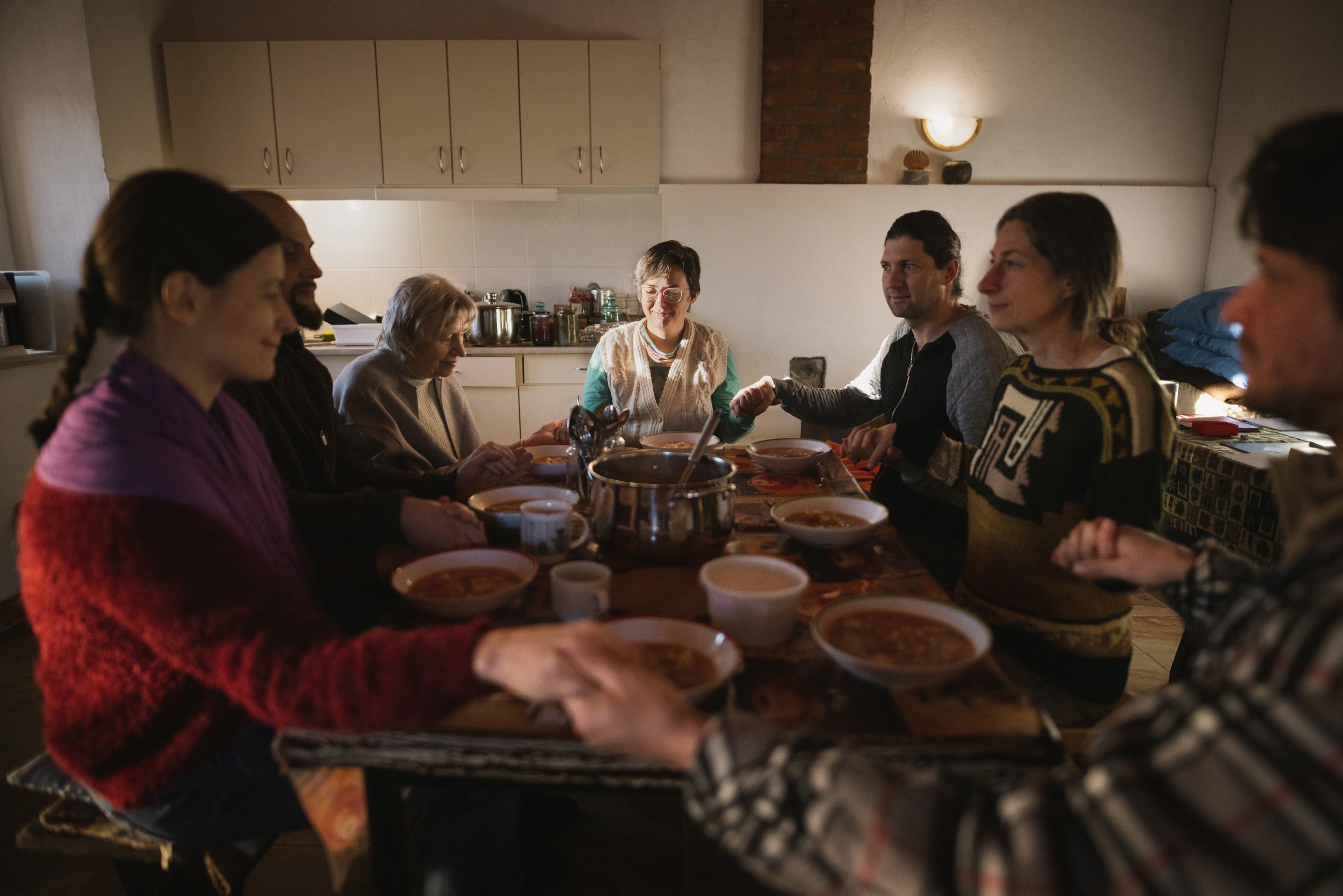  Some members of the Nyim Eco Community and one of their guests hold hands to thank each other for the food and the company on December 31, 2022, the last day of the year. In addition to maintaining ecological standards, the group’s primary responsib