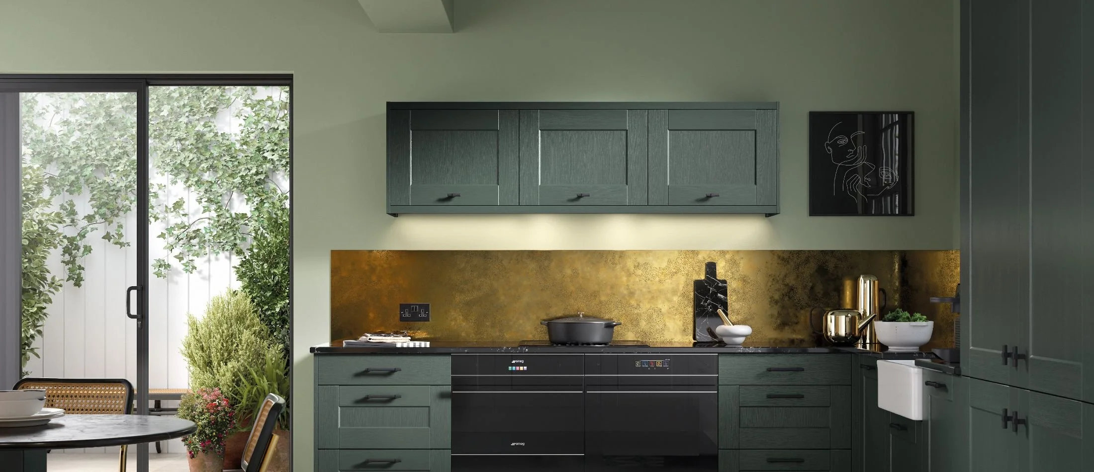 Modern kitchen with dark green cabinets, gold backsplash, and a sliding glass door leading to an outdoor garden.