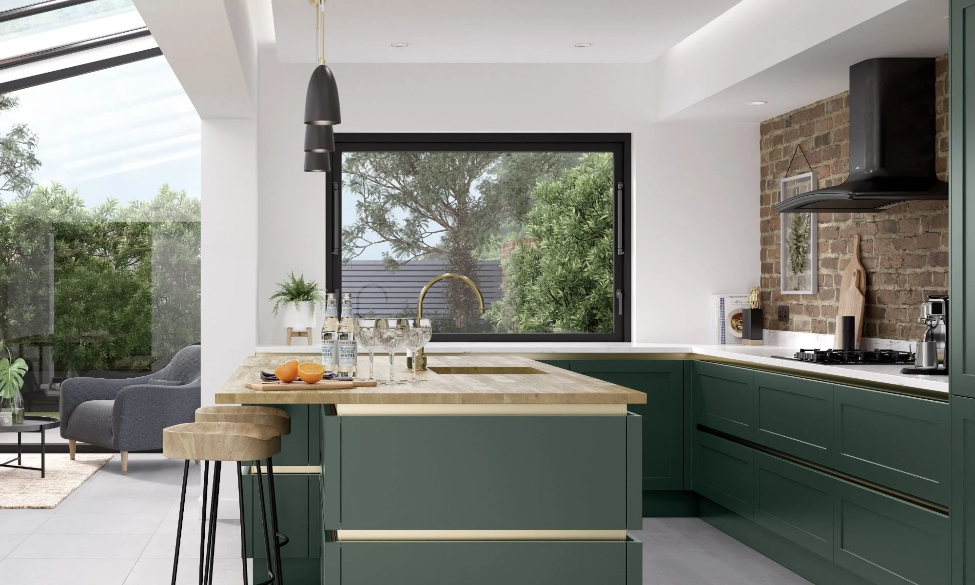 Modern kitchen with green cabinets, black range hood, brick wall, large window overlooking greenery, kitchen island with apples, cut oranges, water bottles, paper towels, and glassware. Adjacent living area with gray armchairs and a side table.