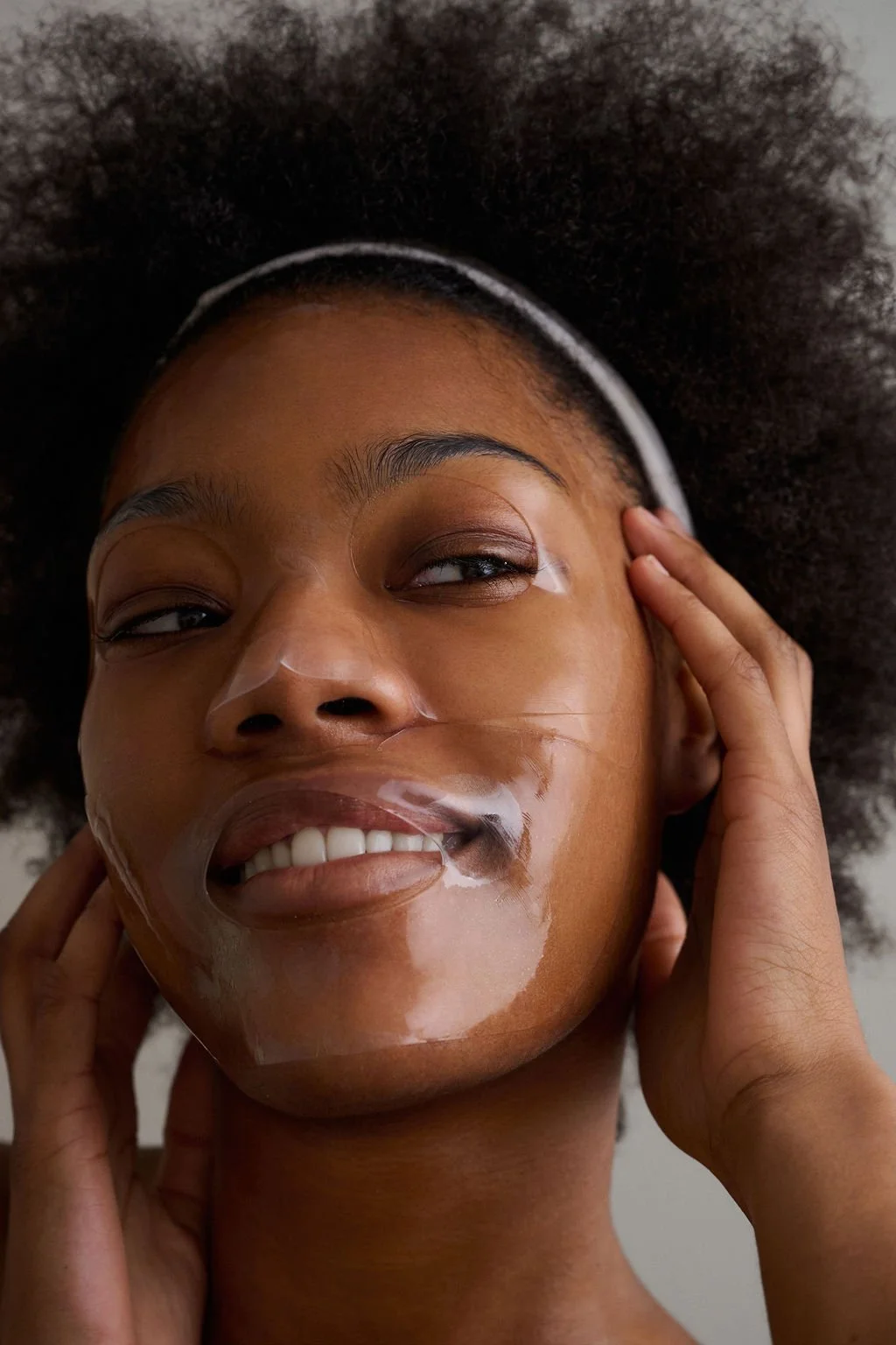 Close-up of a person with a green clay face mask, focused on forehead and nose area.