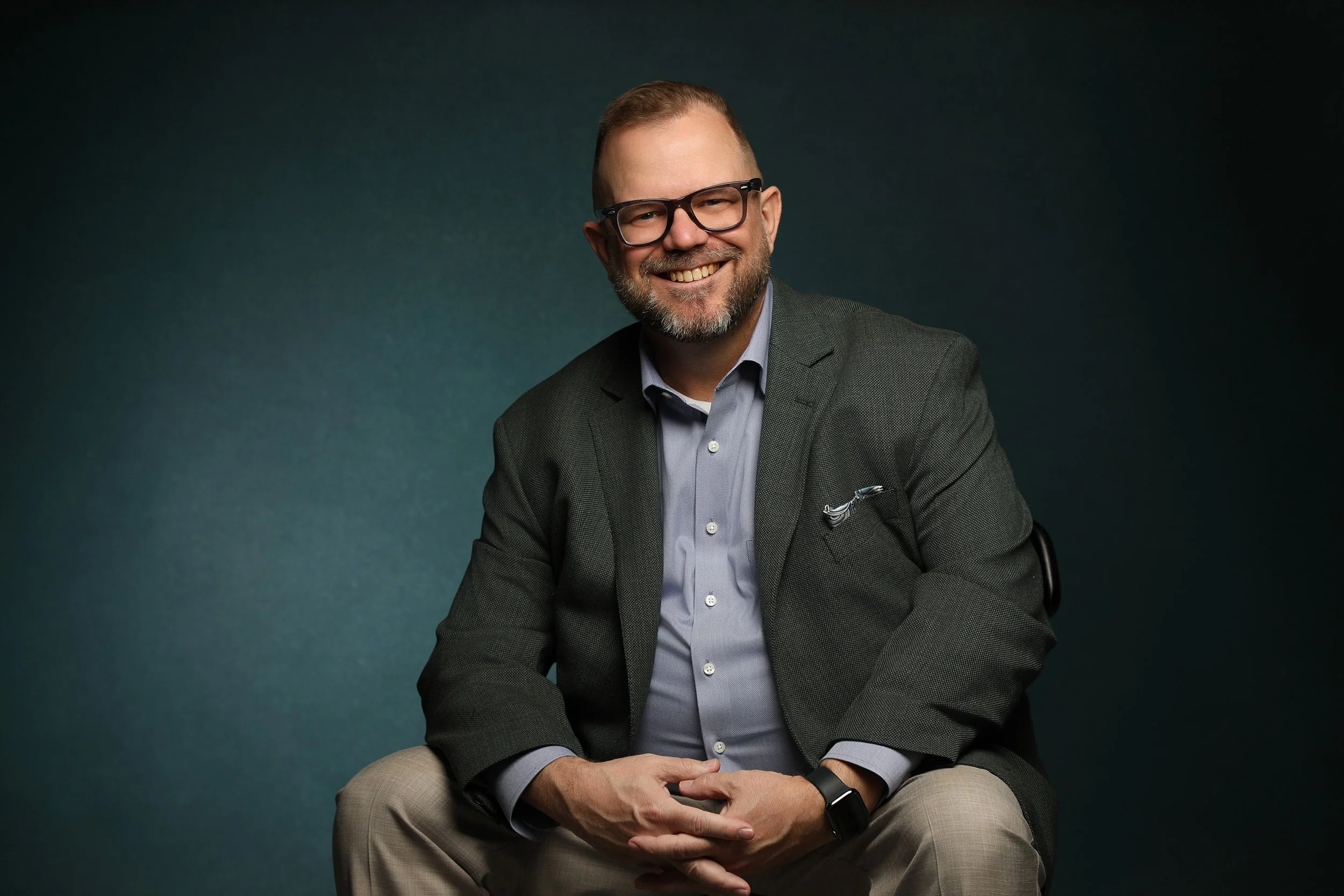 headshot of a man sitting in a chair