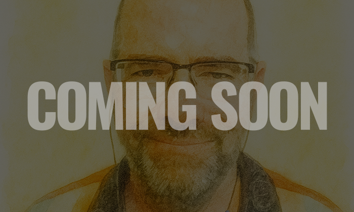 A smiling man wearing glasses with the text "Coming Soon" overlayed on the image.