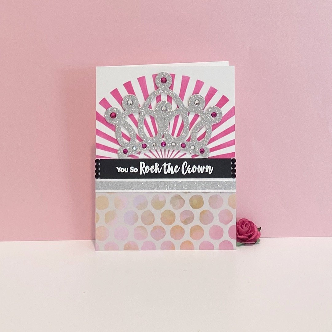 Greeting card with crown design and text on pink.