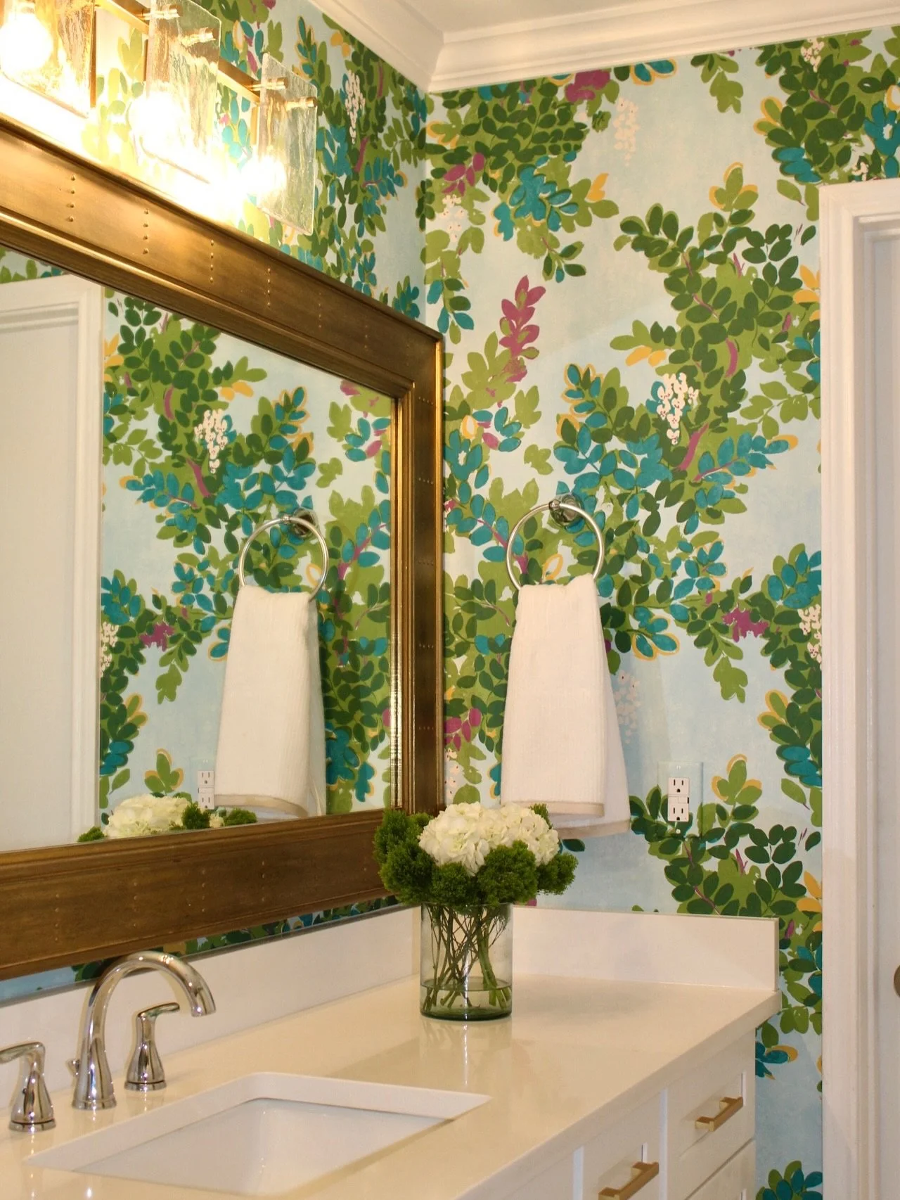 Throwback Thursday to what this bathroom USED to be! Swipe to see the before! What was once a plain, builder-grade bathroom is now a vibrant, personality-filled retreat. Bold wallpaper, brass accents, and crisp white finishes completely transformed t