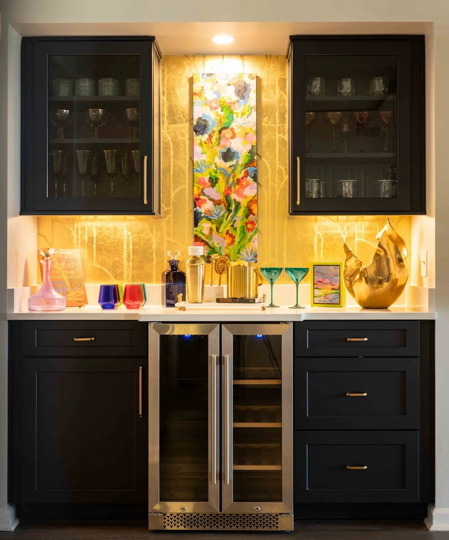 From boring built-in desk to The Treasure Chest ✨🍸⚜️
What was once a forgotten nook is now dripping in moody glamour, golden glow, and just enough mischief. Navy cabinetry, layered brass, colorful glassware, and a little art moment turned this space