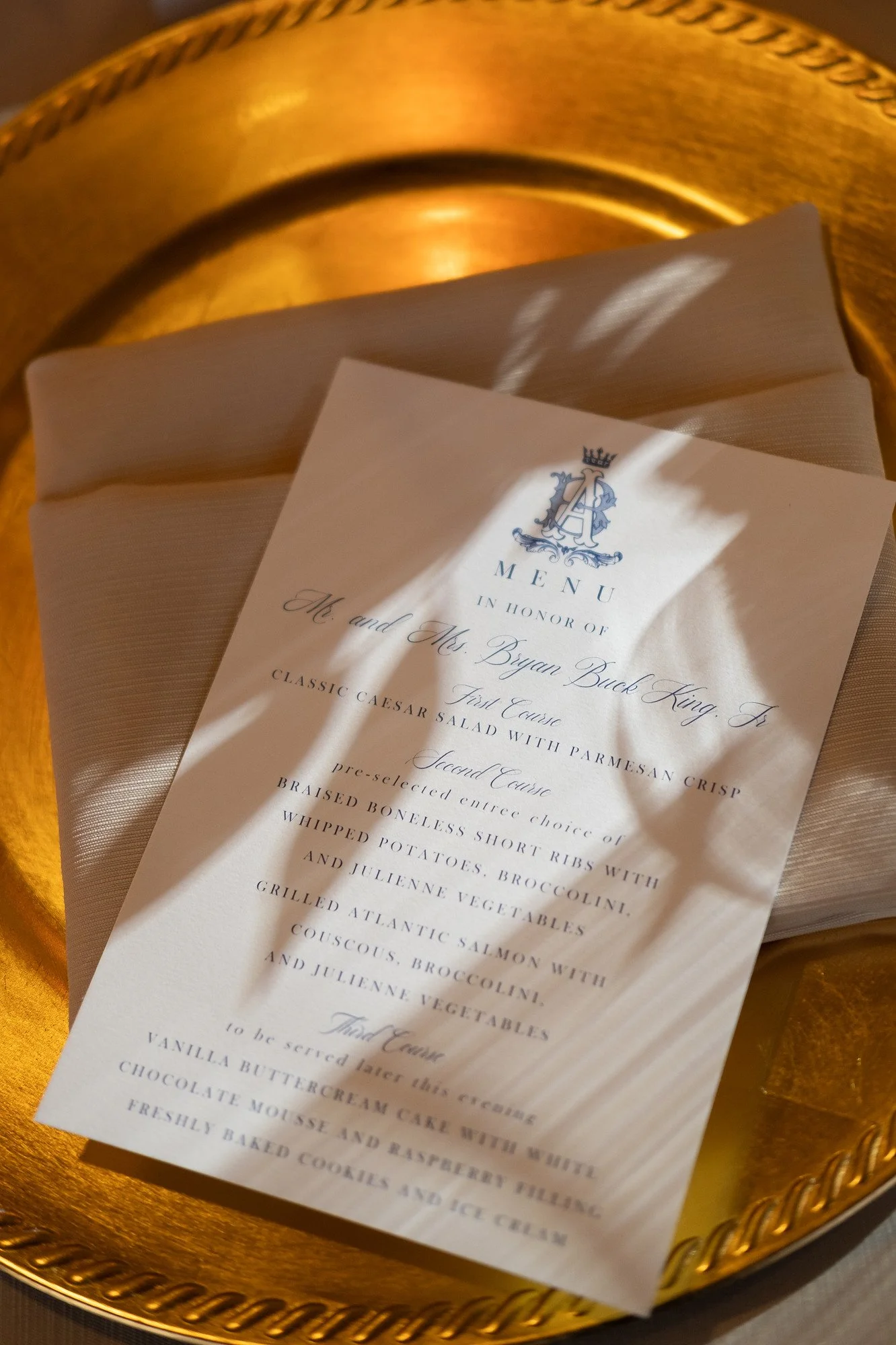 Wedding menu on white paper with gold decorative plate underneath