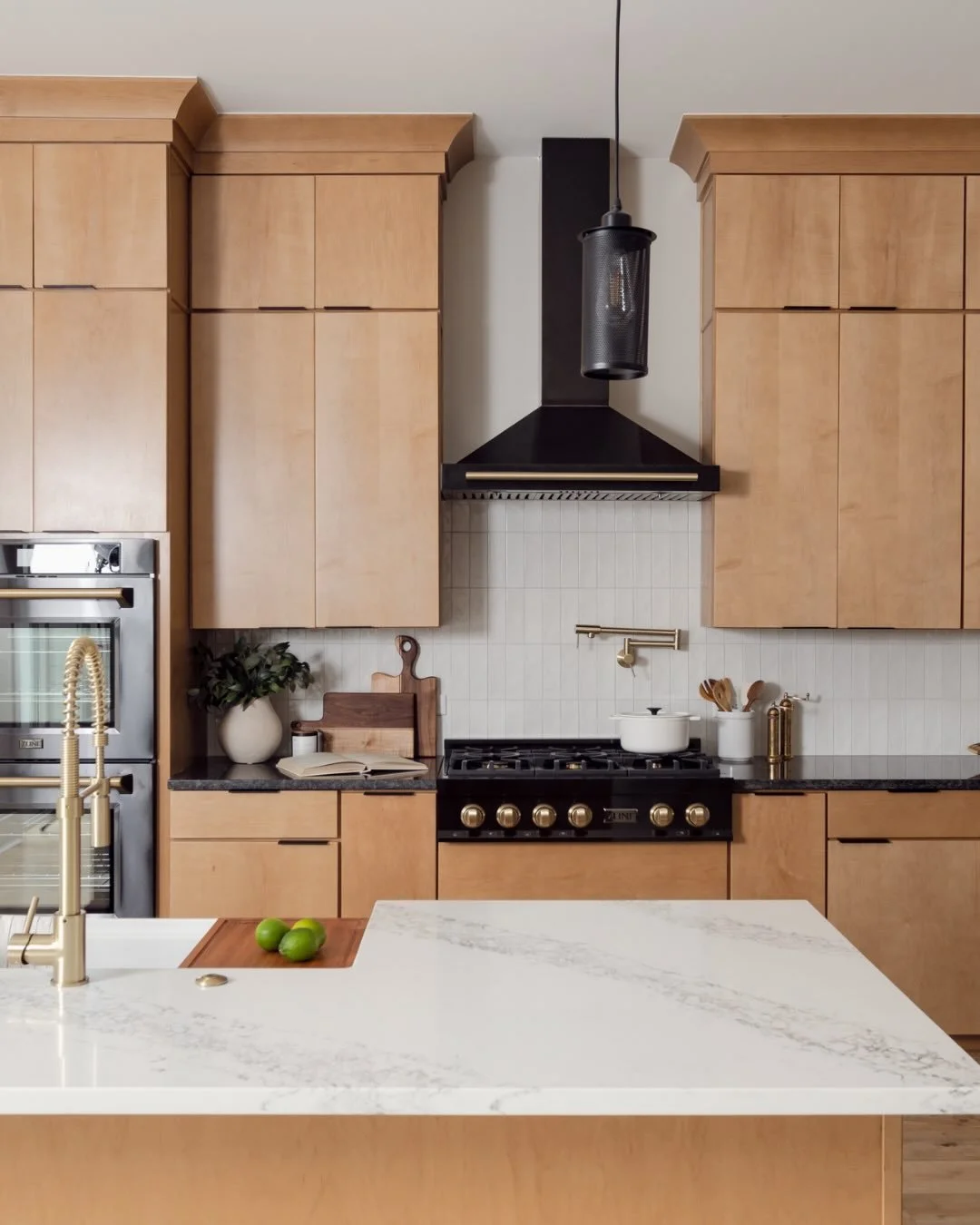This kitchen is all about balance &mdash; organic wood cabinetry brings warmth and character, while modern black appliances add contrast and structure. Classic white tile keeps the space feeling clean and timeless, allowing the materials to speak for