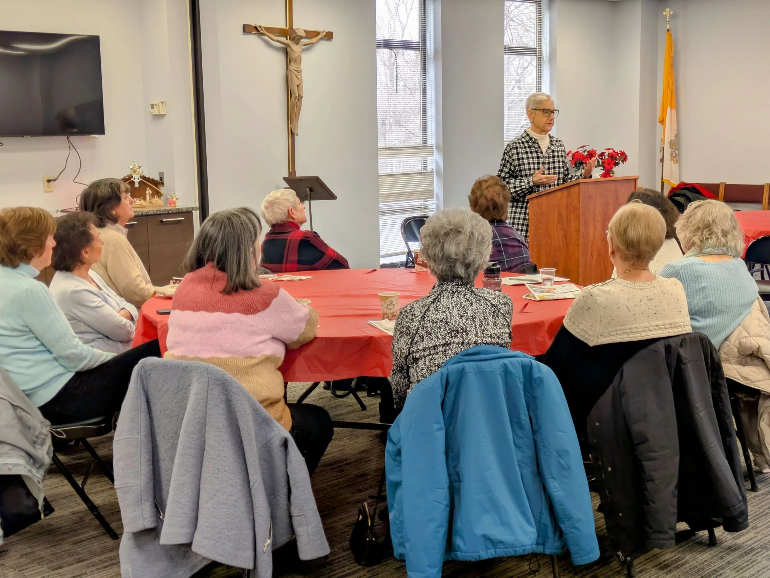 Senior women sitting at a round table facing a speaker
