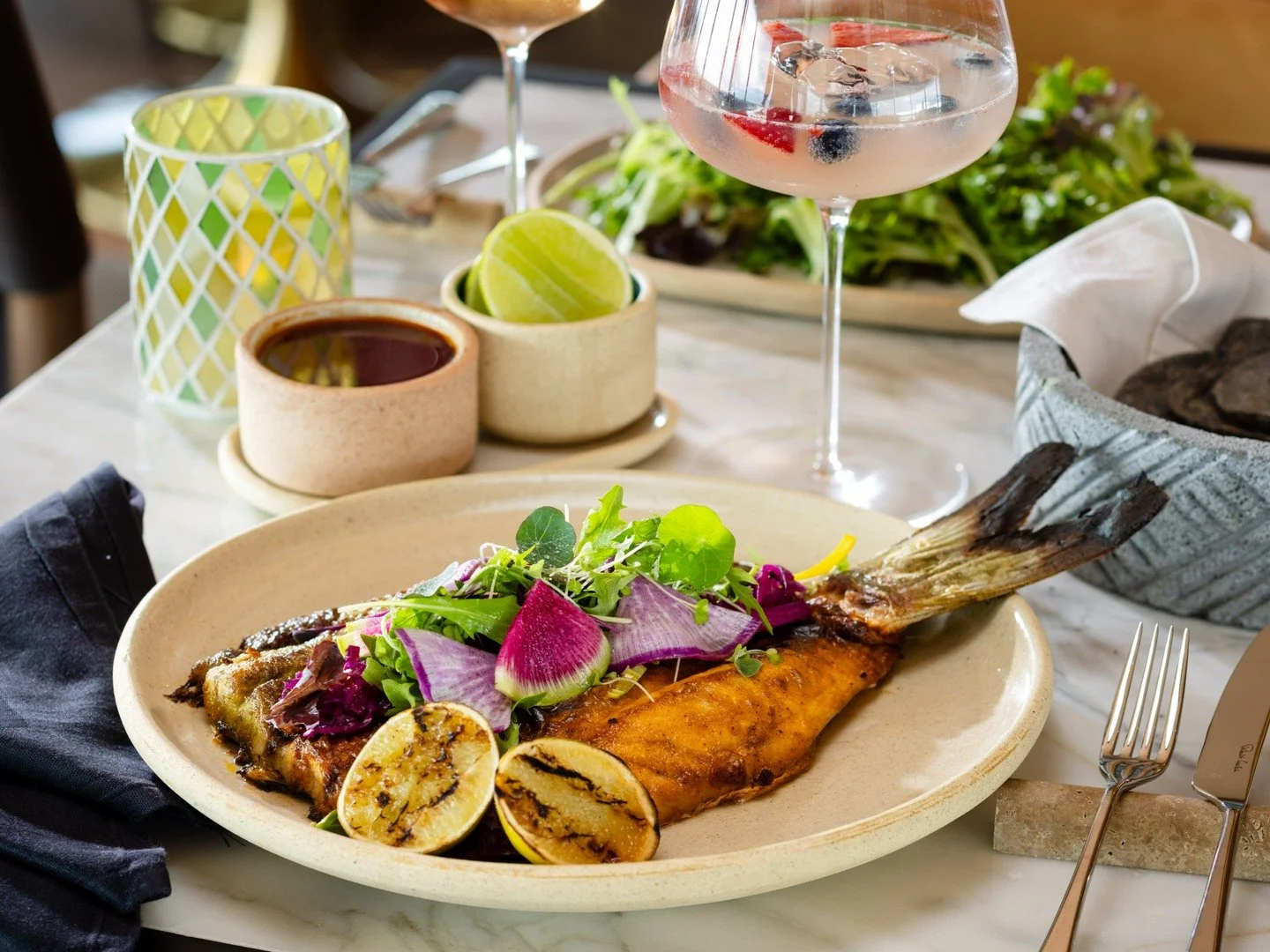Pescado Zarandeado begins with the whole fish of the day, marinated in chile guajillo and ancho before meeting the flame. 🔥

The result is smoky and layered with heat, balanced by red cabbage relish and bitter greens that bring brightness and textur