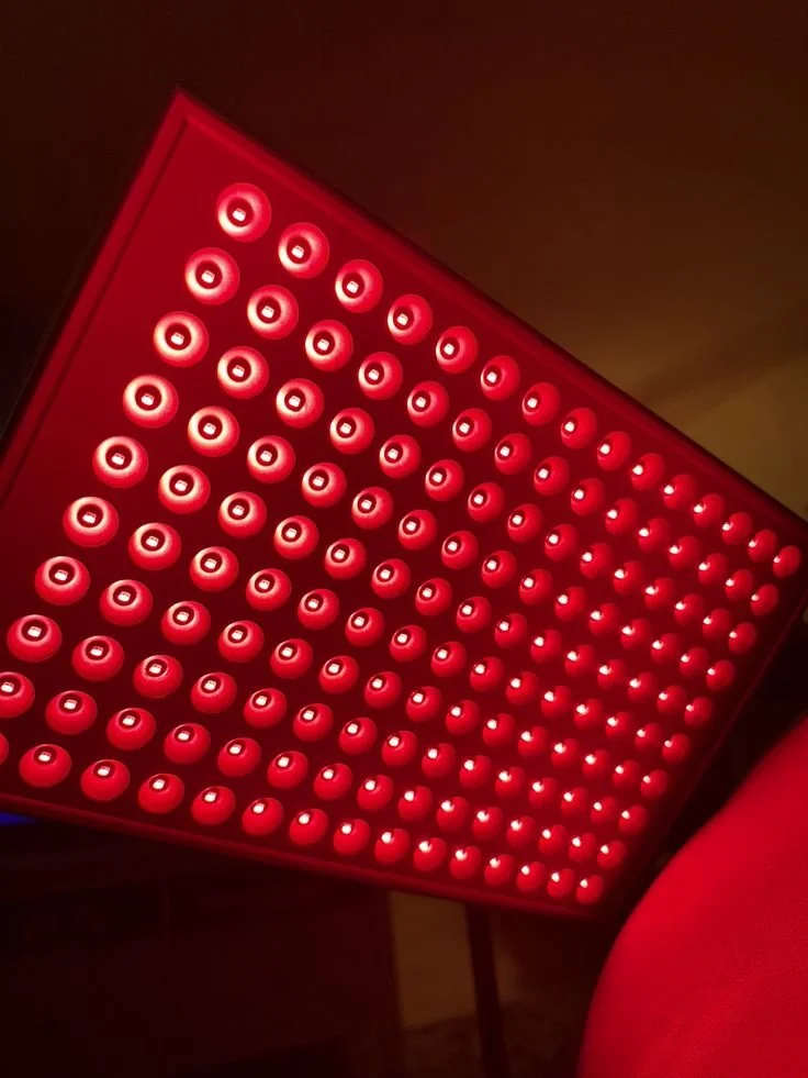 Red LED light therapy device with multiple circular light bulbs arranged in a grid.
