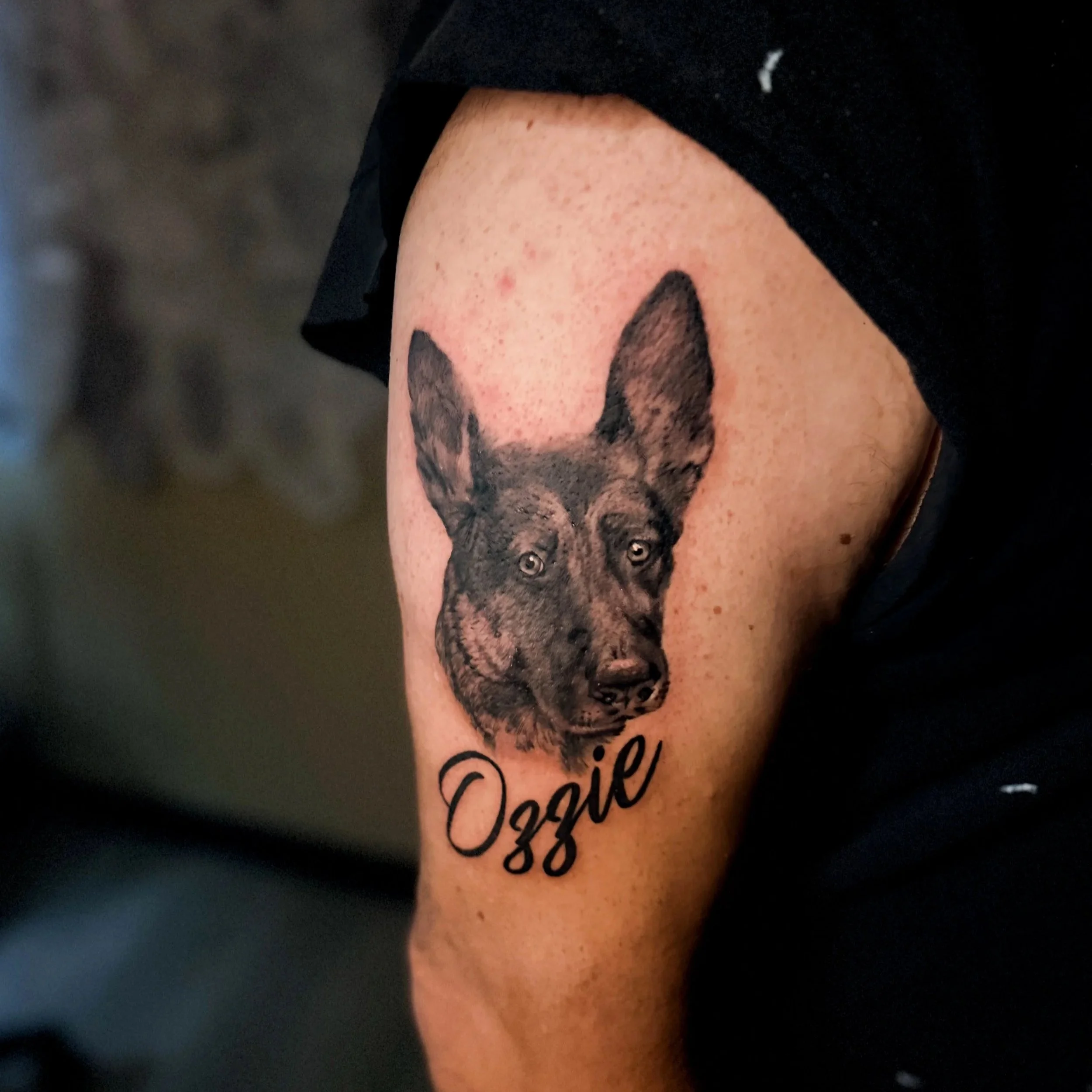 Close-up of a person's skin with a tattoo of a dog and the words 'Dog Dad' written below it.