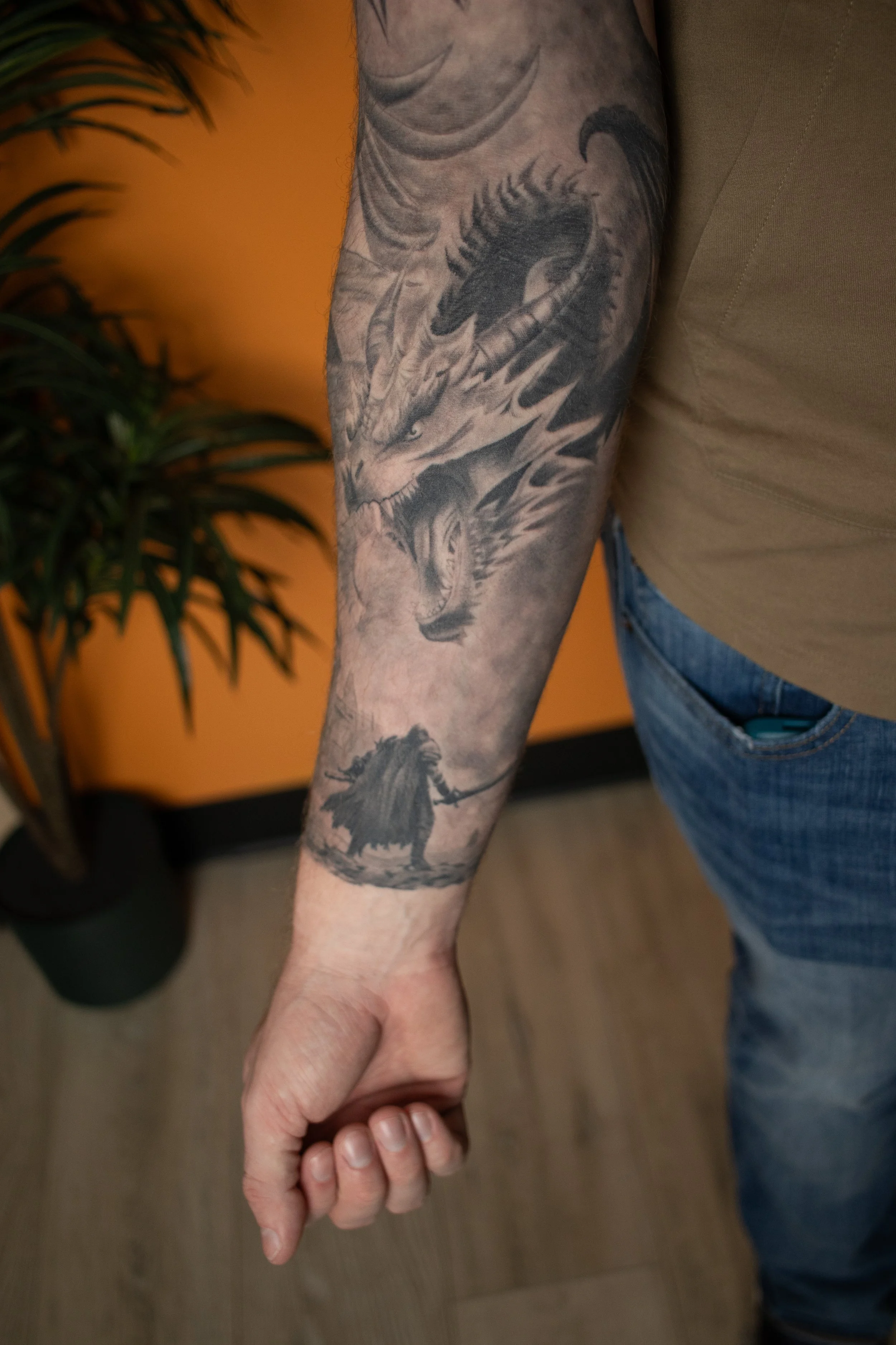 Tattoo of a dragon and a lion on a person's forearm.