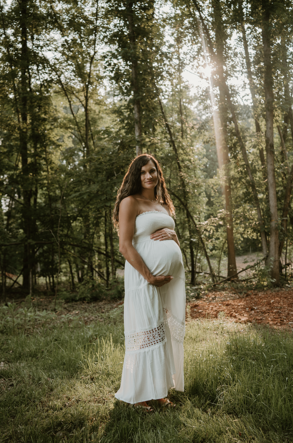 maternity session in field with sun in background